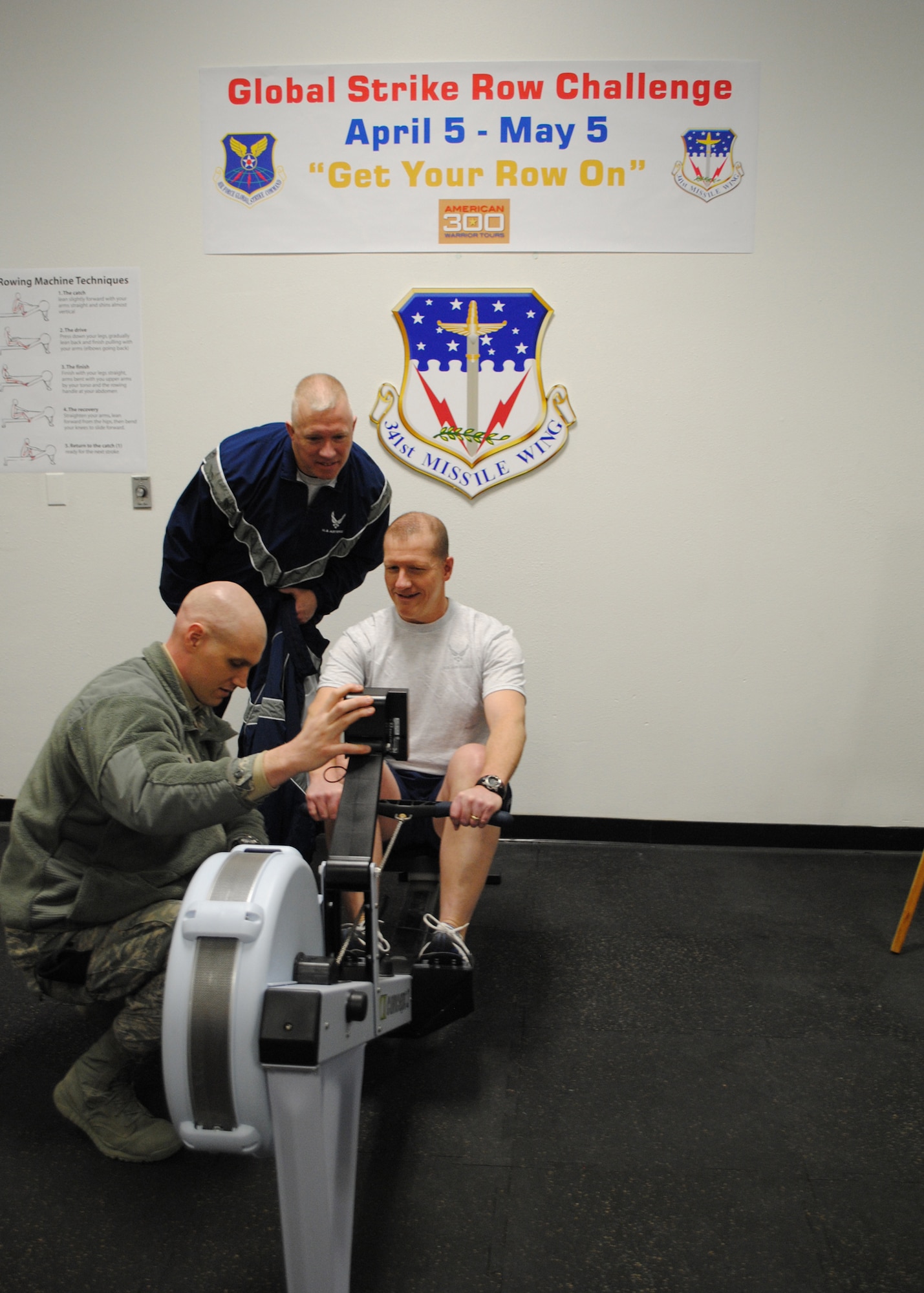 Col. Robert Stanley, 341st Missile Wing vice commander, prepares to kick off the Air Force Global Strike Command rowing challenge for Malmstrom by rowing the first 500 meters on the rowing machine April 5 as Capt. Michael Cheatham, 741st Missile Security Forces Squadron operation officer (left), and Chief Master Sgt. Derick Stepp, 341st Missile Security Forces Squadron security forces manager, count him down.  (U.S. Air Force photo/Airman 1st Class Cortney Paxton)