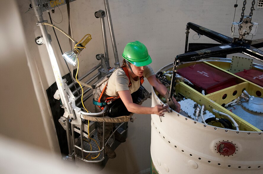 Senior Airman Jessica Kulla, 90th Missile Maintenance Squadron, detaches the sling that lowered a new post boost control system onto a Minuteman III missile in a 90th Missile Wing launch facility March 29. (U.S. Air Force photo by R. J. Oriez)