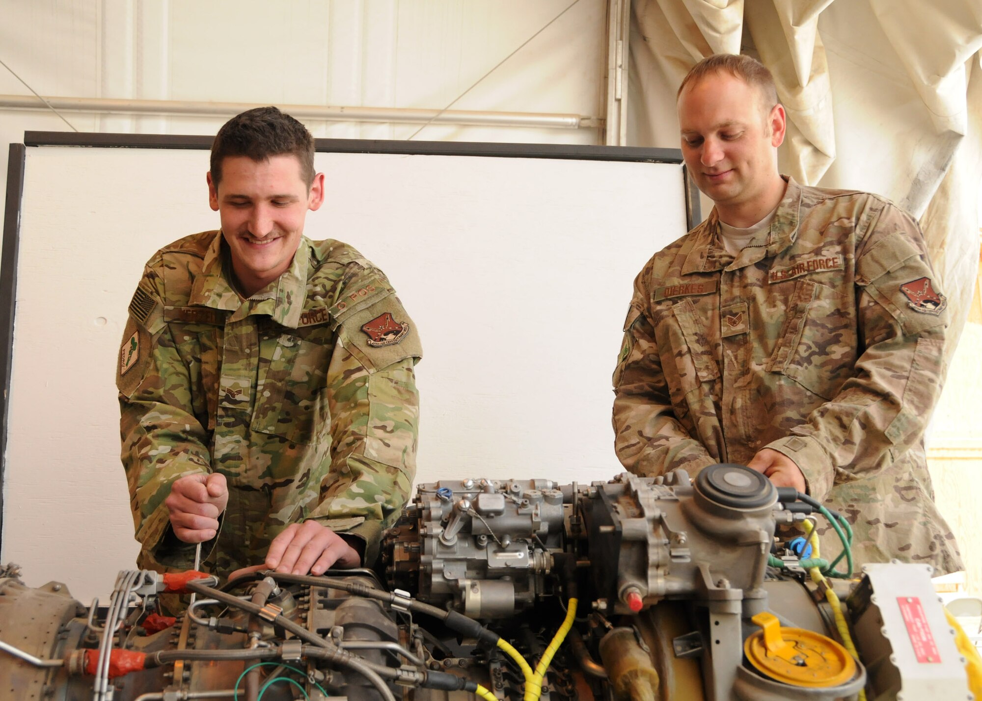 Senior Airman Christopher Verzella and Staff Sgt. Nathan Dierkes, 55th Expeditionary Helicopter Maintenance Unit aerospace propulsion technicians, check over an engine that needs repair at Kandahar Airfield, Afghanistan, March 30.