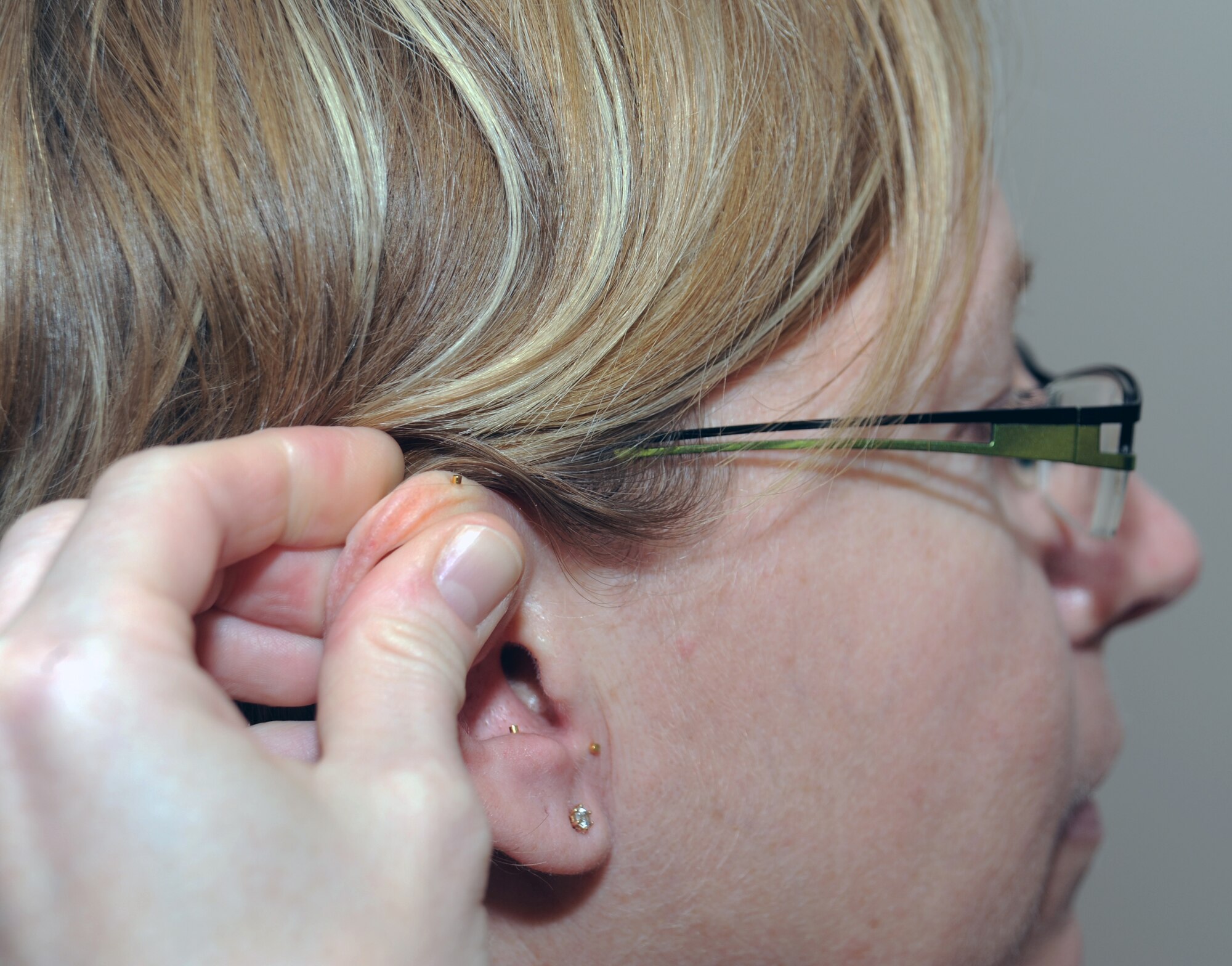 SOUTHWEST ASIA - Lt. Col. (Dr.) Darlene Smallman applies acupuncture needles to Maj. Amber Hirsch's ear April 4, 2012. Hirsch suffers from hip pain and has found acupuncture the only treatment that helps her. Smallman, a flight surgeon deployed to the 380th Air Expeditionary Wing from the Pentagon, studied at the Air Force Acupuncture Center on Joint Base Andrews, Md. Hirsch is the wing judge advocate. (U.S. Air Force photo/Staff Sgt. J.G. Buzanowski)