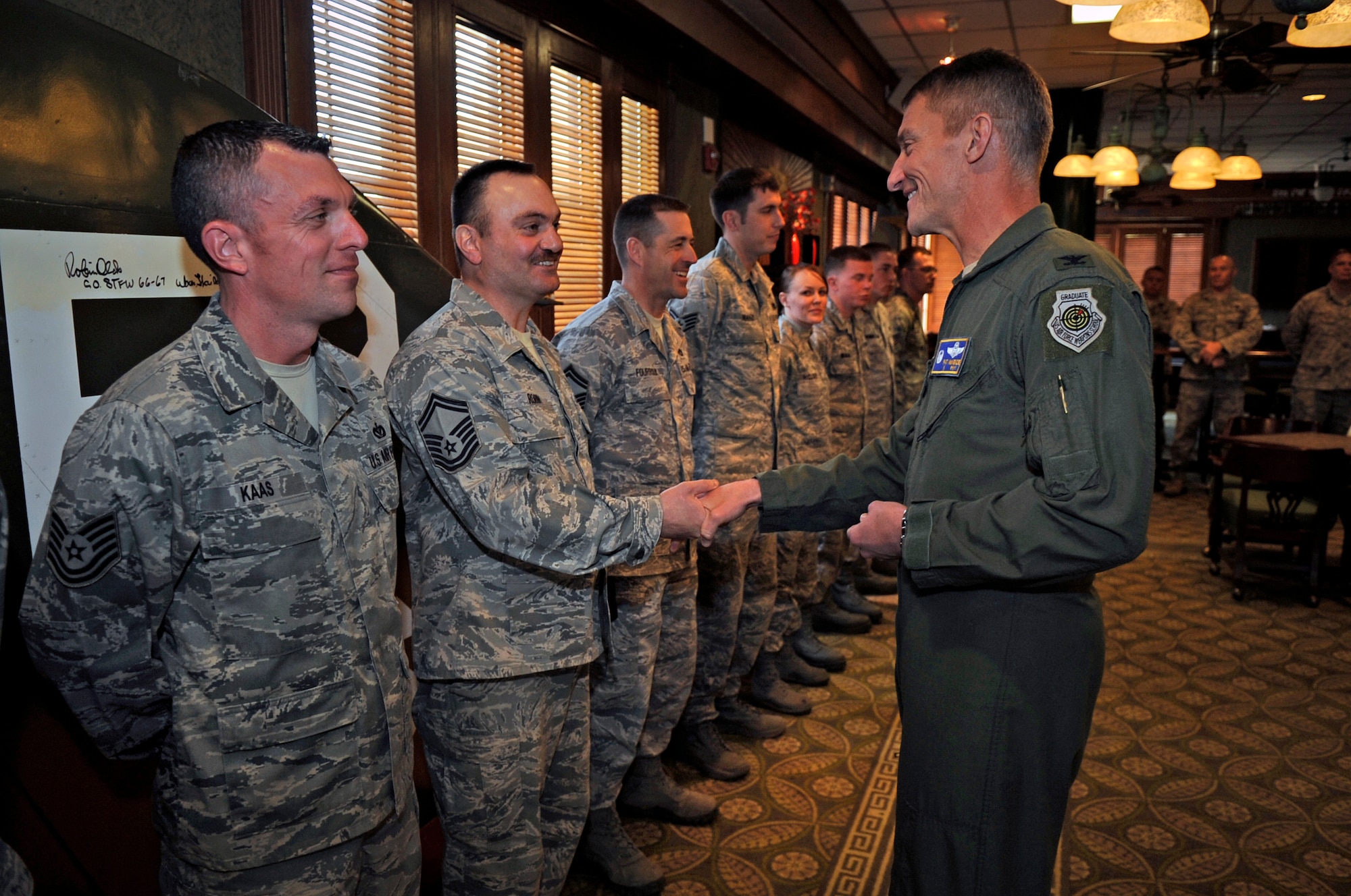 Col. Patrick McKenzie, 51st Fighter Wing commander from Osan Air Base, Republic of Korea, coins one of 13 Wolf Pack Airmen at the Loring Club, on Kunsan Air Base, ROK, April 6, 2012. Each of the 13 Airmen were recognized by leadership for their exceptional hard work and dedication to the emergency response efforts following an Air Force F-16 Fighting Falcon crash near Kunsan AB in March. 