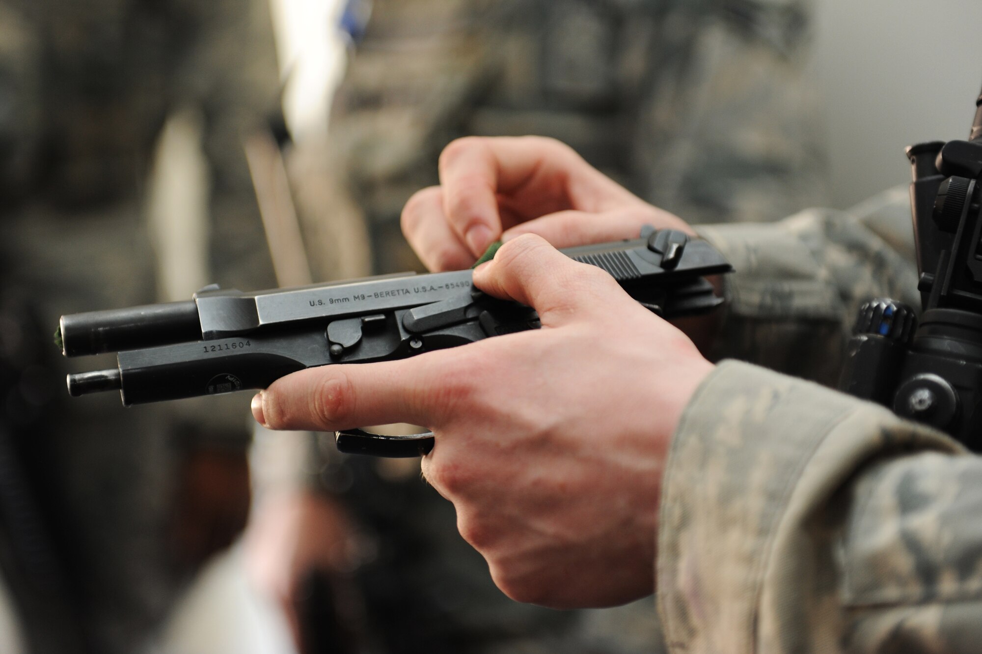 U.S. Air Force Airman 1st Class Alec Foor, 35th Security Forces Squadron defender, puts a 550 cord into his M-9 pistol during High Risk Response Training at Misawa Air Base, Japan, March 30, 2012. The 550 cord is inserted into the pistol as a training tool to allow everyone to know that the weapon is clear of ammunition.  Regular training exercises like this, gave 35 SFS Airmen the ability to develop the skills and knowledge that resulted in the squadron earning the Air Force Outstanding Security Forces Medium Unit 2011. (U.S. Air Force photo by Airman 1st Class Kia Atkins/Released)