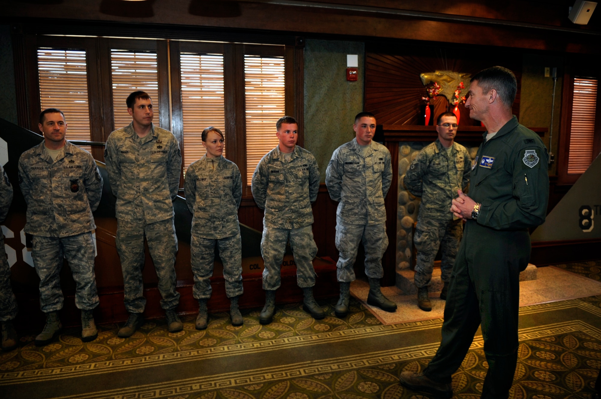 Col. Patrick McKenzie, 51st Fighter Wing commander from Osan Air Base, Republic of Korea, talks with Wolf Pack Airmen at the Loring Club, on Kunsan Air Base, ROK, April 6, 2012, who were instrumental to the emergency response efforts following an Air Force F-16 Fighting Falcon crash near Kunsan AB in March.