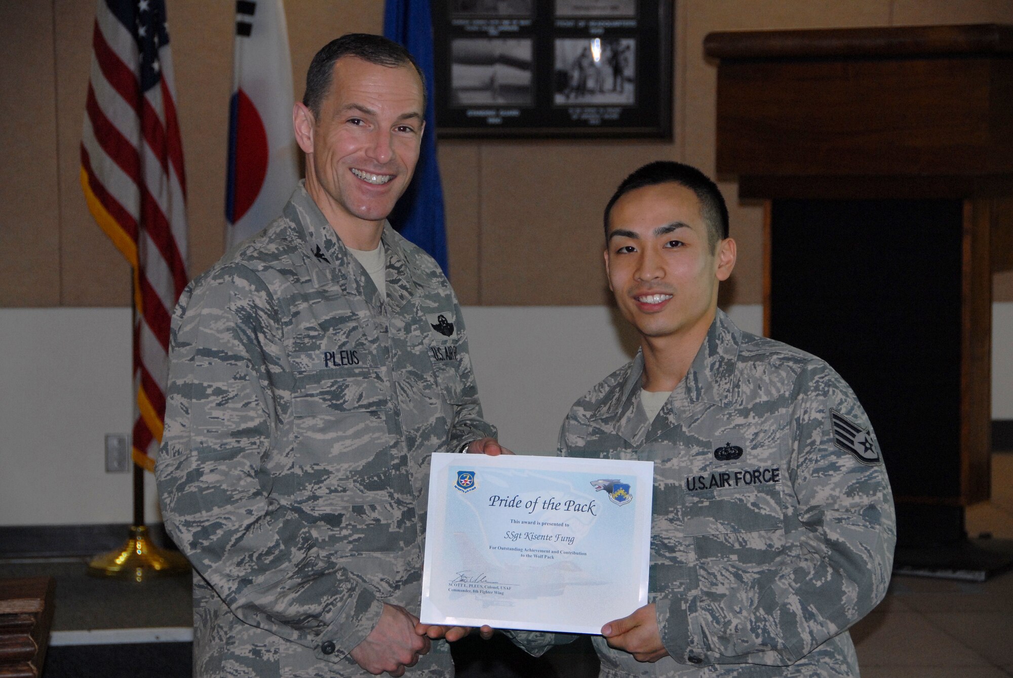 Col. Scott L. Pleus, 8th Fighter Wing commander, presents Staff Sgt. Kisente Fung, 8th Communications Squadron client systems technician, with Kunsan’s Pride of the Pack, which recognizes the outstand work Airmen do every day.  (U.S. Air Force photo by Capt. Omar Villarreal/ Released)
