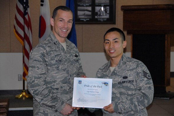 Col. Scott L. Pleus, 8th Fighter Wing commander, presents Staff Sgt. Kisente Fung, 8th Communications Squadron client systems technician, with Kunsan’s Pride of the Pack, which recognizes the outstand work Airmen do every day.  (U.S. Air Force photo by Capt. Omar Villarreal/ Released)
