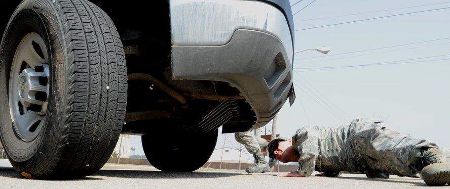 Senior Airman Joe Bromley, 8th Maintenance Squadron, checks under a vehicle for any suspicious items as part of his training to become an 8th Security Forces Squadron augmentee, April 4, 2012, Kunsan Air Base, Republic of Korea. The four-day class exposes Airmen from other careers to traditional security forces techniques, including vehicle searching and challenging procedures. (U.S. Air Force photo/Senior Airman Brigitte N. Brantley)