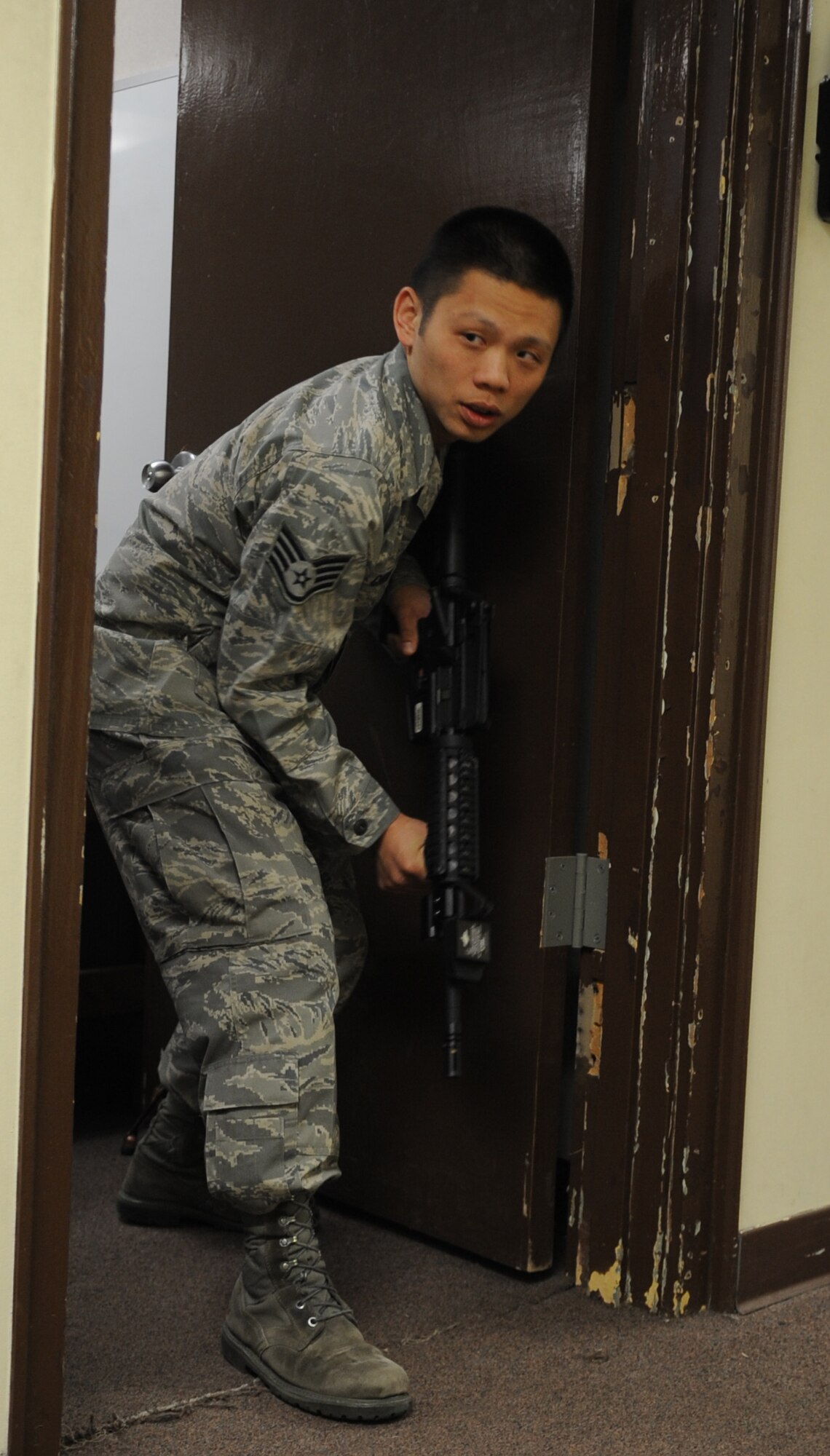 Staff Sgt. Alman Chiang, 8th Fighter Wing Command Post, clears the hallway before stepping out with his team during a security forces augmentee training class at Kunsan Air Base, Republic of Korea, April 5, 2012. During the four-day class, augmentees learned how to apprehend people, search vehicles and clear buildings. (U.S. Air Force photo/Senior Airman Brigitte N. Brantley)