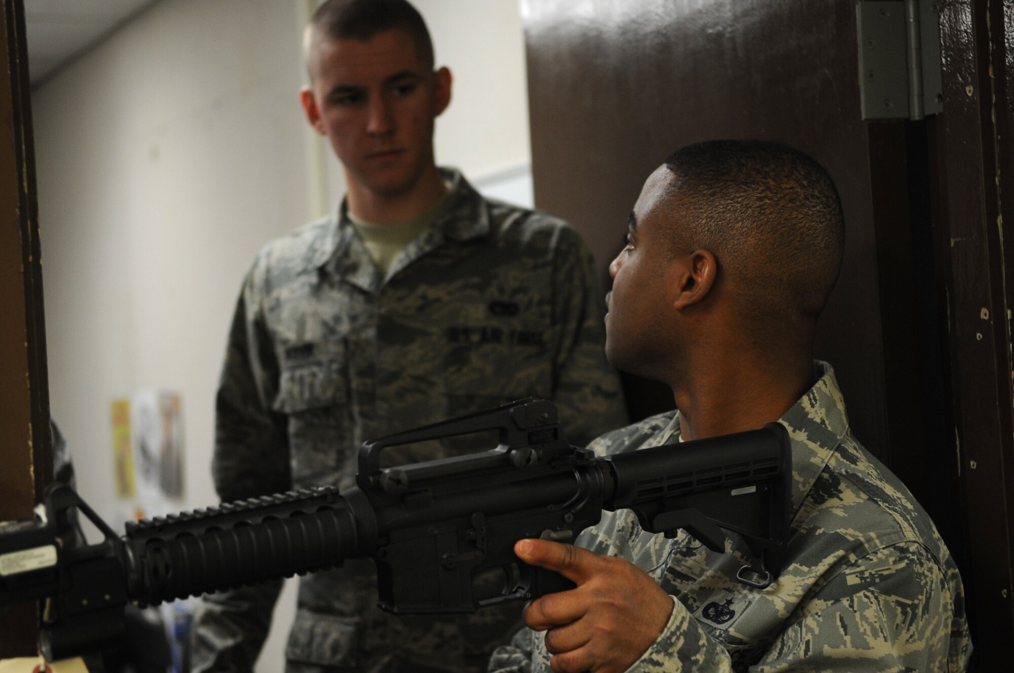 From right, Staff Sgt. Frank Simpson, 8th Security Forces Squadron augmentee program manager, demonstrates proper clearing techniques to Airman 1st Class Michael Hoivik, 8th Logistics Readiness Squadron, during an augmentee training class April 5, 2012, at Kunsan Air Base, Republic of Korea. Simpson taught the students how to clear buildings in teams of two, three and four. (U.S. Air Force photo/Senior Airman Brigitte N. Brantley)