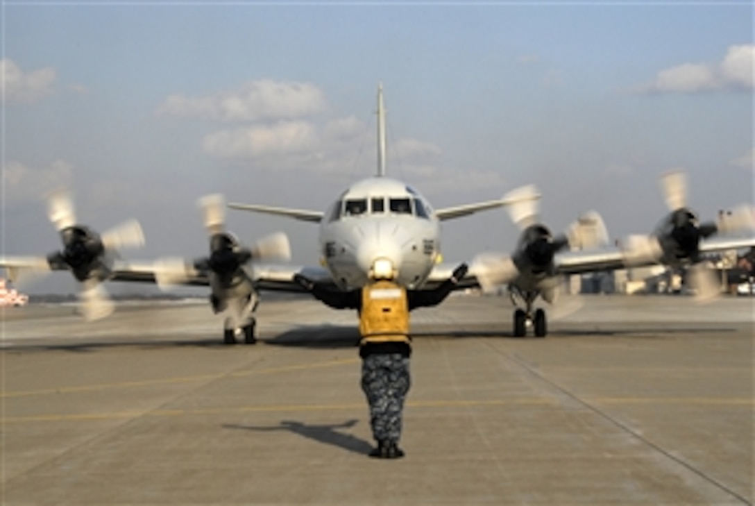 U.S. Navy Airman Mark Jimenez, with Patrol Squadron 1, signals the pilots of a P-3 Orion aircraft before takeoff in northern Japan on April 5, 2012.  Patrol Squadron 1 is on deployment in support of 7th Fleet operations.  