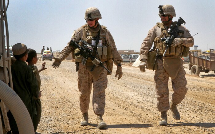 U.S. Marine Sgt. Maj. Brett C. Scheuer, 2nd Battalion, 9th Marine Regiment sergeant major, reaches out to shake an Afghan boy’s hand as he and Sgt. Maj. Alberto Ruiz, Regimental Combat Team 5 sergeant major, patrol to an Afghan Civil Order Police station here, April 6, 2012. Colonel Roger Turner, the RCT-5 commanding officer, and Ruiz visited Marines and Afghan National Security Forces at several combat outposts throughout Helmand province’s Marjah.
