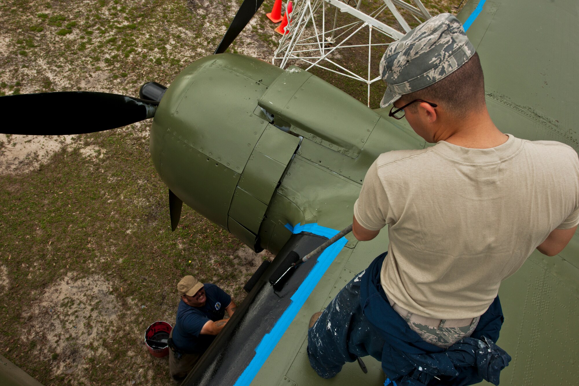 Airman 1st Class Anthony Colon-Matos, of the 96th Logistics Readiness Squadron, paints the wing of the B-25 aircraft display at the Air Force Armament Museum, April 5.  Colon-Matos and other members of LRS’s petroleum, oil and lubricants flight restored the B-25 as part of Eglin’s Adopt-a-Plane program.  LRS adopted the B-25 six years ago.  This is the second time the squadron’s Airmen have painted it.  (U.S. Air Force photo/Samuel King Jr.)