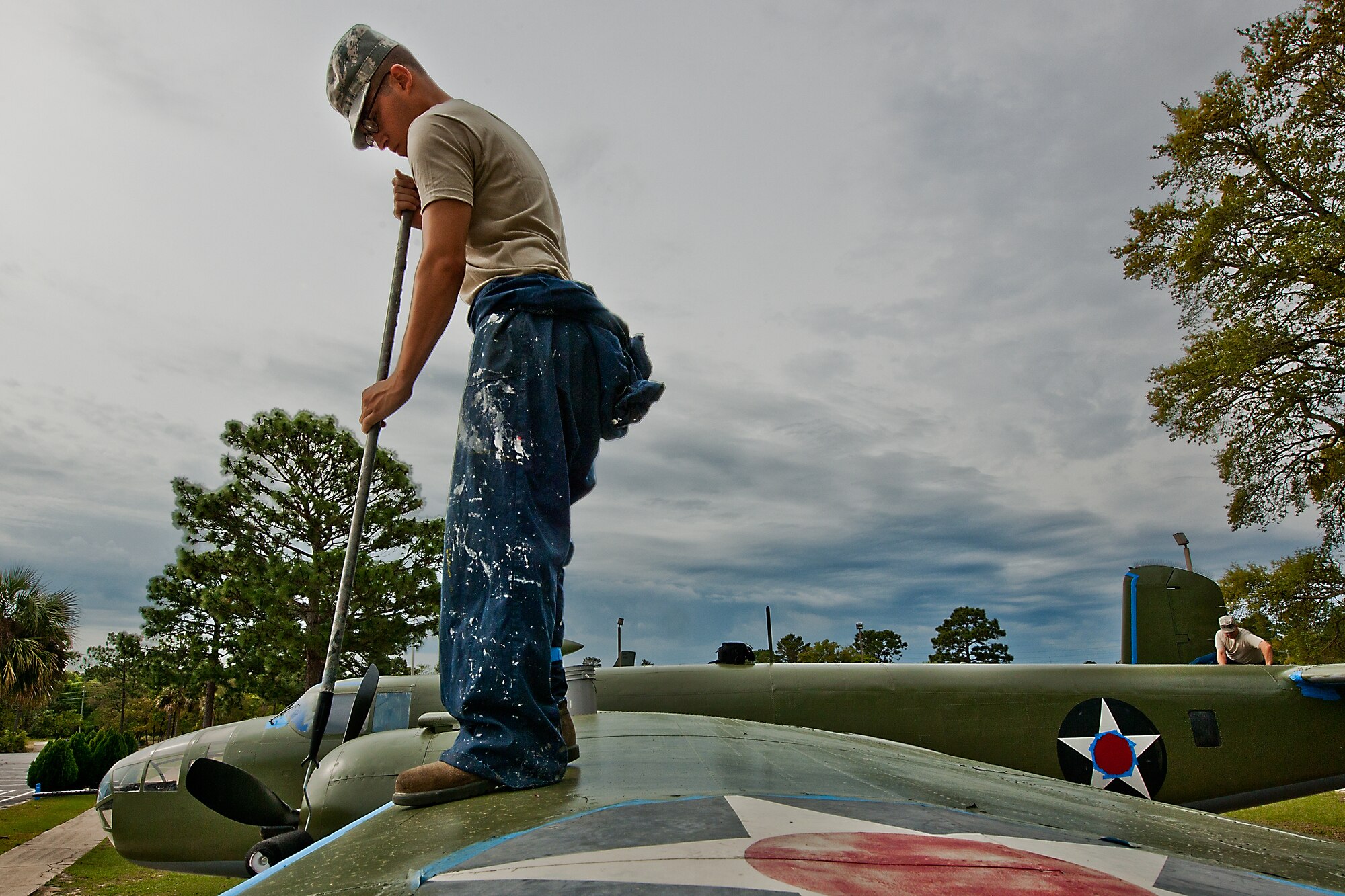 Airman 1st Class Anthony Colon-Matos, of the 96th Logistics Readiness Squadron, paints the wing of the B-25 aircraft display at the Air Force Armament Museum, April 5.  Colon-Matos and other members of LRS’s petroleum, oil and lubricants flight restored the B-25 as part of Eglin’s Adopt-a-Plane program.  LRS adopted the B-25 six years ago.  This is the second time the squadron’s Airmen have painted it.  (U.S. Air Force photo/Samuel King Jr.)