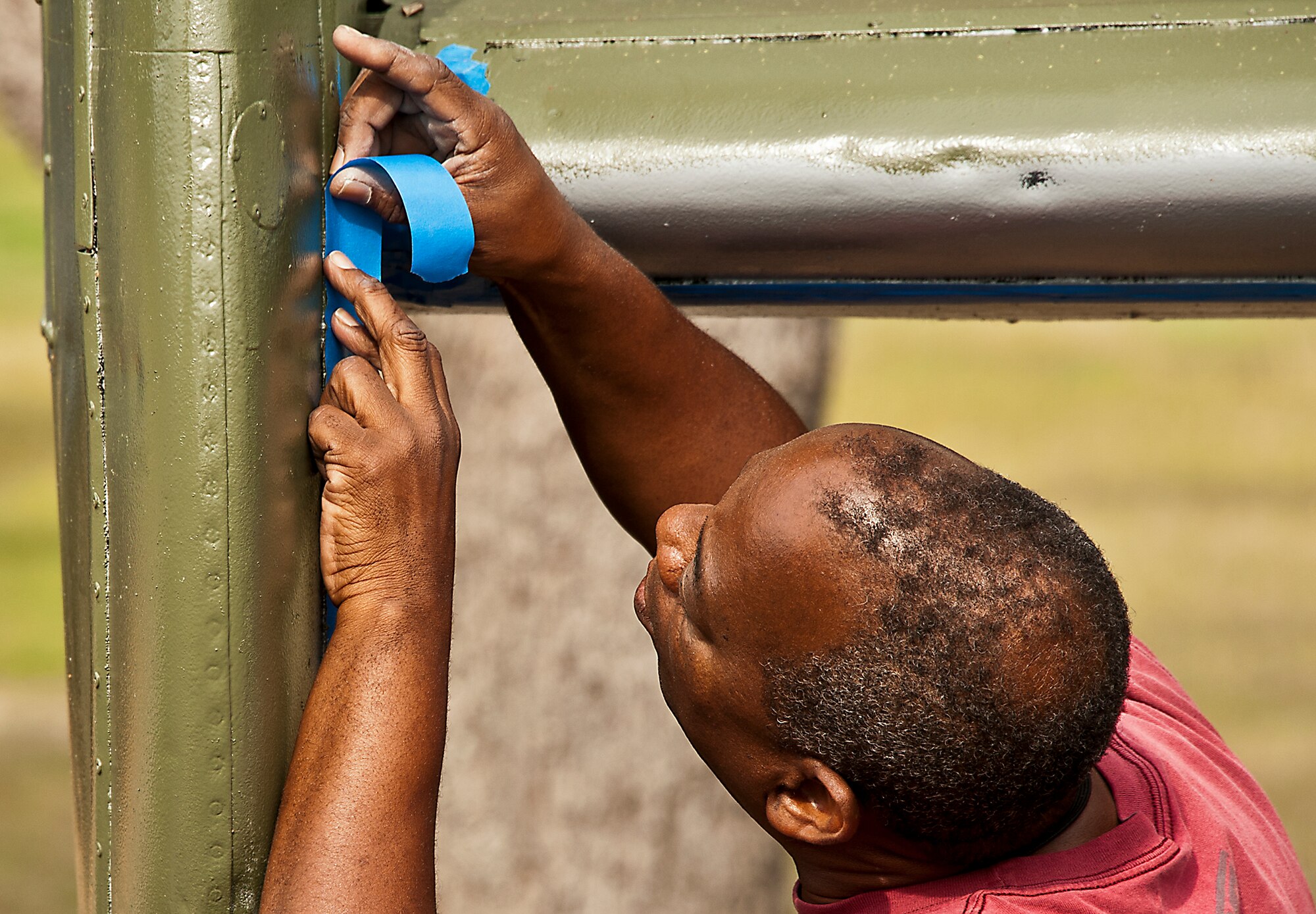 Nate Rudison, of the 96th Logistics Readiness Squadron, places painters tape on the B-25 aircraft display of the B-25 aircraft display at the Air Force Armament Museum, April 5.  Rudison and other members of LRS’s petroleum, oil and lubricants flight restored the B-25 as part of Eglin’s Adopt-a-Plane program.  LRS adopted the B-25 six years ago.  This is the second time the squadron’s Airmen have painted it.  (U.S. Air Force photo/Samuel King Jr.)