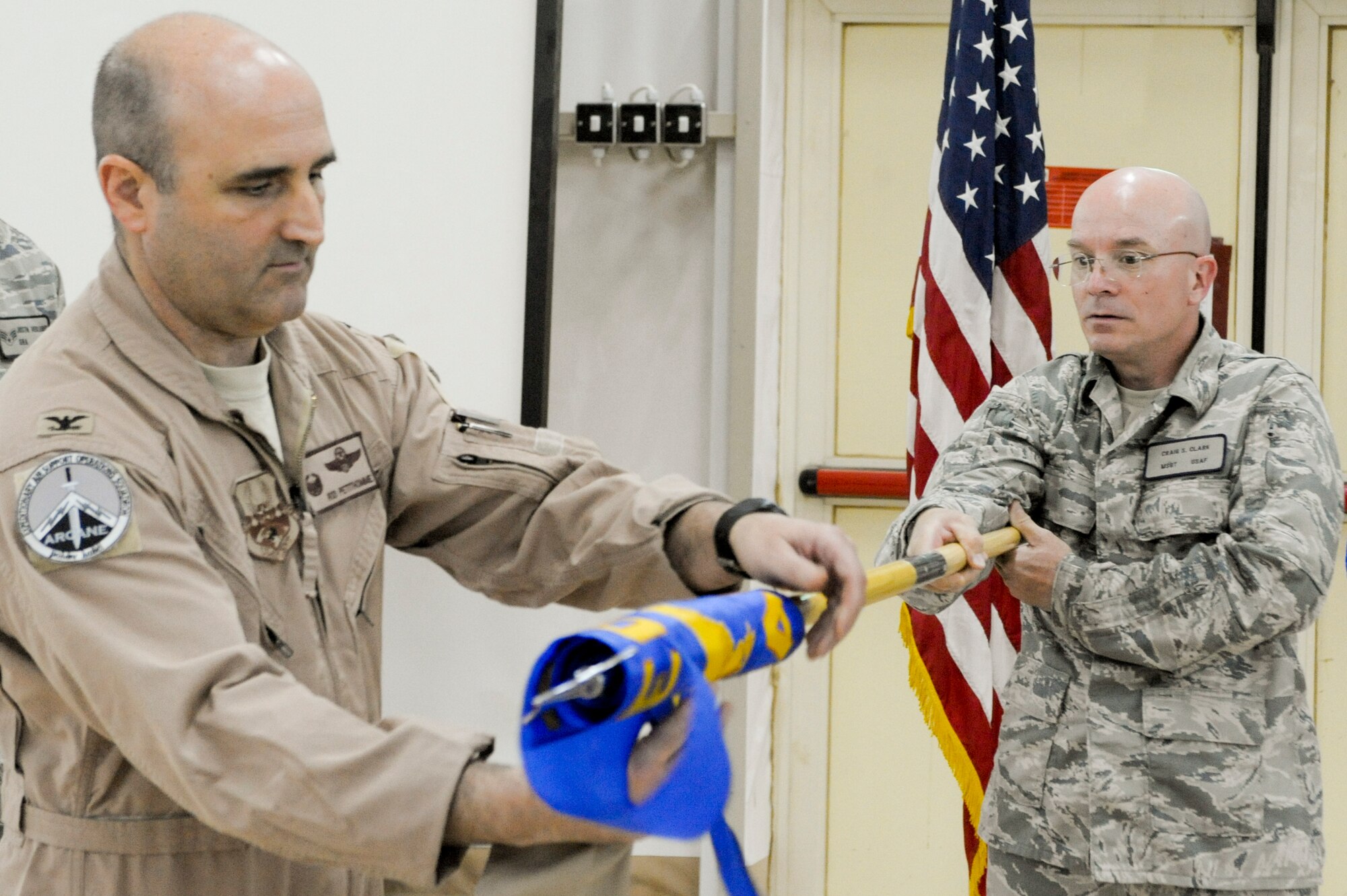 CAMP BUEHRING, KUWAIT -- Col. Rodney Petithomme, 332nd Expeditionary Operations Group commander, unveils the guidon as Master Sgt. Craig Clark, 82nd Expeditionary Air Support Operations Squadron first sergeant, holds it during the unit’s activation ceremony here, April 6, 2012. The tradition of an activation ceremony dates back to the reign of Frederick the Great of Prussia. Petithomme is deployed from Osan Air Base, Korea, and is a native of Clovis, Calif. Clark is deployed from Ft. Bliss, Texas. (U.S. Air Force photo by Staff Sgt. Joshua J. Garcia)