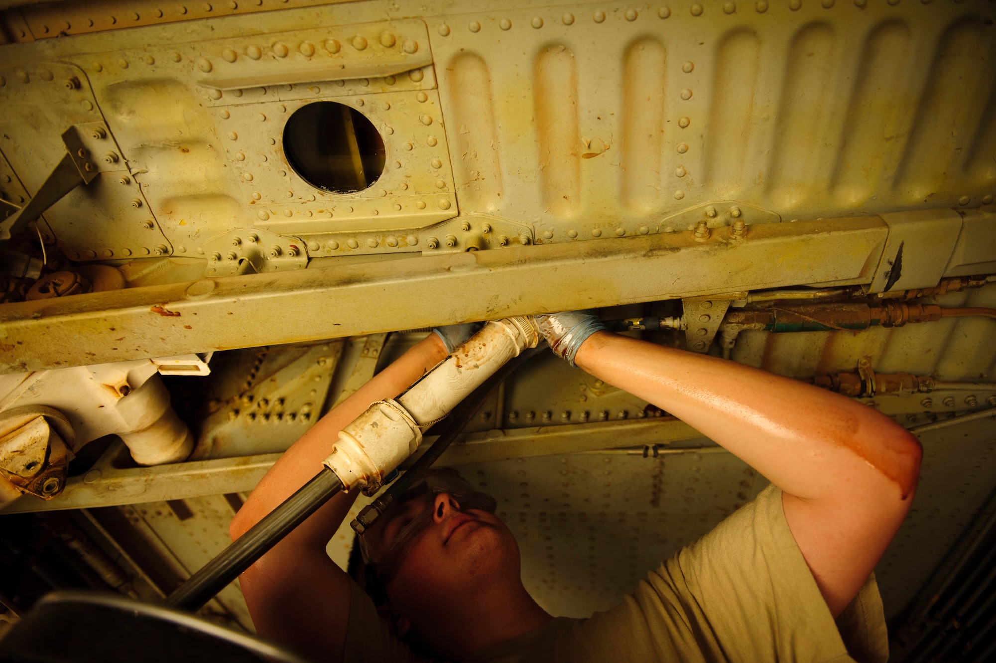 SOUTHWEST ASIA – Airman 1st Class Johnathan Holmes, 340th Expeditionary Aircraft Maintenance Unit hydraulics specialist and native of Hampden, Maine, removes a hydraulic line attached to the side strut actuator for the main landing gear on a KC-135 Stratotanker here April 4. The hydraulics system must be de-pressurized prior to making any adjustments to the system. (U.S. Air Force photo/Staff Sgt. Nathanael Callon)