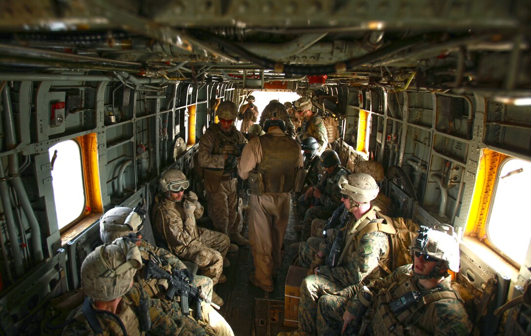 Staff Sgt. Hugo Paniagua, an Aerial Observer with Marine Heavy Helicopter Squadron 362 and Brooklyn, N.Y., native, helps Marines from Weapons Company, 3rd Battalion, 3rd Marine Regiment, get seated as they board a CH-53D Sea Stallion at Forward Operating Base Delhi, Afghanistan, April 7, 2012.