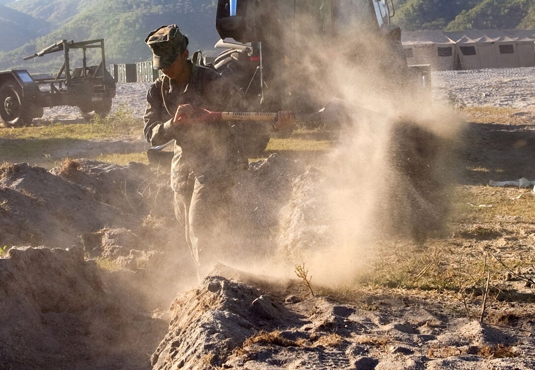 Lance Cpl. Jaquelyn Bautista, a communications clerk with Combat Logistics Battalion 3, buries fiber-optic cable the Crow Valley camp site, April 8. Bautista is part of a communications embarkment team from 3rd Marine Division that is working alongside CLB-3 in support of Balikatan 2012.