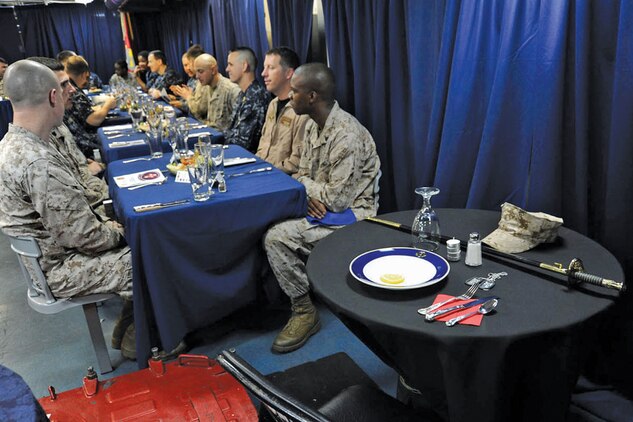 Marine Fighter Attack Squadron 251 Corporal’s Course, Class 1-12 hosts a field mess night while aboard aircraft carrier USS Enterprise (CVN 65) April 9. A single table draped in black cloth stands alone to represent those who lost their lives in our nation’s wars.