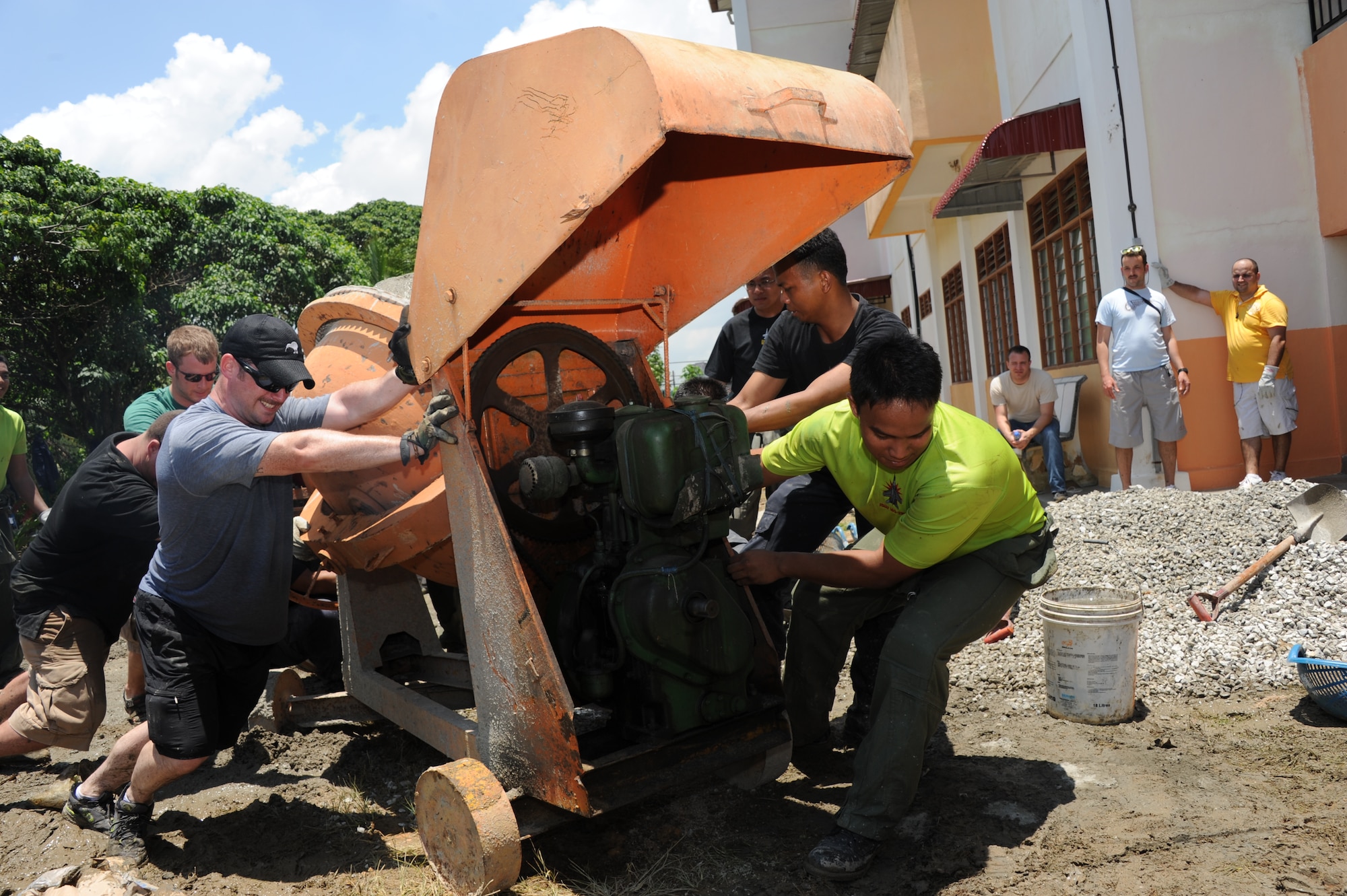 U.S. Air Force and Royal Malaysian Air Force airmen team up to move a concrete mixer at the Pembangunan Anak-Anak Yatim Bekas Perajurit Malaysian orphanage in Kulim, Malaysia, on April 8, 2012.  More than 50 U.S. and Malaysian air force members spent the day mixing and pouring concrete to create a multi-use sports court at the orphanage as part of a humanitarian construction project held during Cope Taufan 2012. Exercise Cope Taufan 12 is a Pacific Air Forces sponsored exercise involving dissimilar basic fighter maneuver and dissimilar air combat tactics training with the U.S. and Royal Malaysian Air Forces at Tudm Butterworth, Malaysia, 4-13 Apr 12.(U.S. Air Force photo/Master Sgt. Matt Summers)