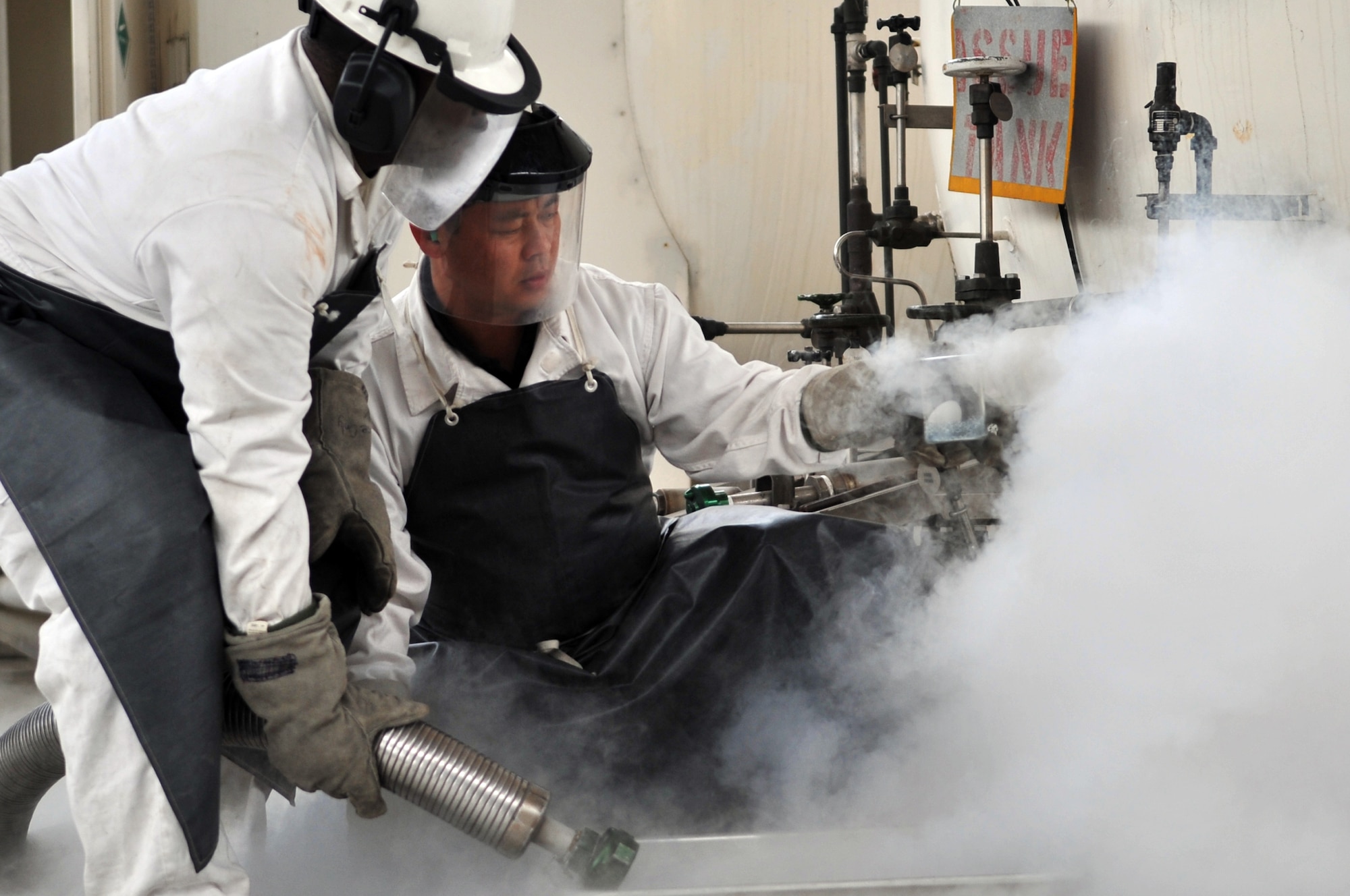 Staff Sgt. James Gardner and Mr. Ki-Hyon Pak, with the 51st Logistics Readiness Squadron, push liquid oxygen into a beaker to perform an odor test here, April 9, 2012. An odor test is one way to test if the liquid oxygen is still in good quality. Gardner is a 51st LRS fuels cryogenic technician and Pak is a cryogenics operator. (U.S. Air Force photo/Staff Sgt. Craig Cisek)