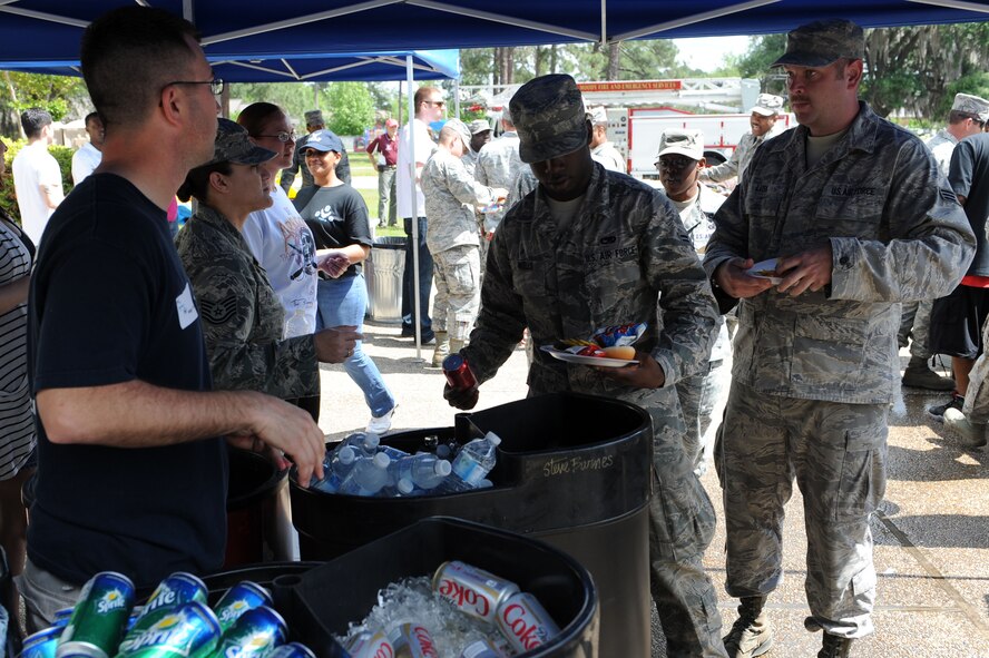 U.S. Air Force Staff Sgt. Michael Youngblood, 23d Force Support Squadron Airmen Leadership School instructor, passes out drinks during a post operational readiness inspection block party at Moody Air Force Base, Ga., April 6, 2012. The party celebrated Moody’s successful passing of the recent ORI. (U.S. Air Force photo by Staff Sgt. Ciara Wymbs/Released)