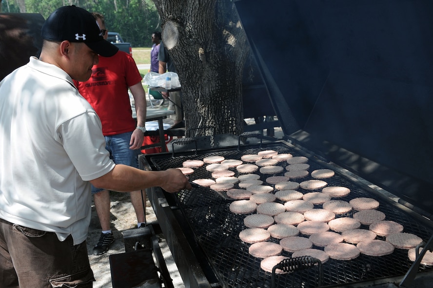 U.S. Air Force Master Sgt. Michael Merritt, 23d Operations Support Squadron, flips burgers at a post operational readiness inspection celebration at Moody Air Force Base, Ga., April 6, 2012. Moody celebrated the completion of the ORI by hosting a party that included games, food and entertainment for the hard work put forth by Airmen. (U.S. Air Force photo by Staff Sgt. Ciara Wymbs/Released)      