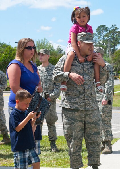 U.S. Air Force Staff Sgt. Timothy Sterling, 23d Maintenance Operation Squadron, carries his daughter on his shoulders while standing in line for food during the 23d Wing post Operational Readiness Inspection party at the President George W. Bush Air Park at Moody Field April 6, 2012, at Moody Air Force Base, Ga. The party was held to celebrate the passing of a recent ORI, and all members of the wing and their families were welcomed to take part in the event's festivities. (U.S. Air Force photo by Senior Airman Eileen Meier/Released)