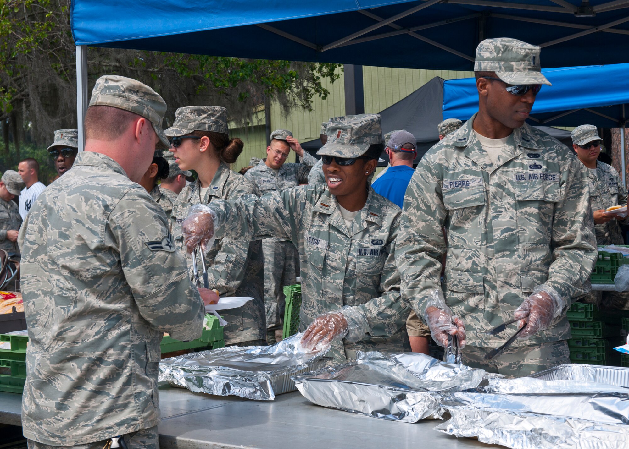 Volunteers for the 23d Wing post Operational Readiness Inspection party hand out food prepared by the Chiefs Group grill masters to members of the wing and their families at the President George W. Bush Air Park at Moody Field April 6, 2012, at Moody Air Force Base, Ga. The event was held in celebration of a successful inspection. (U.S. Air Force photo by Senior Airman Eileen Meier/Released)