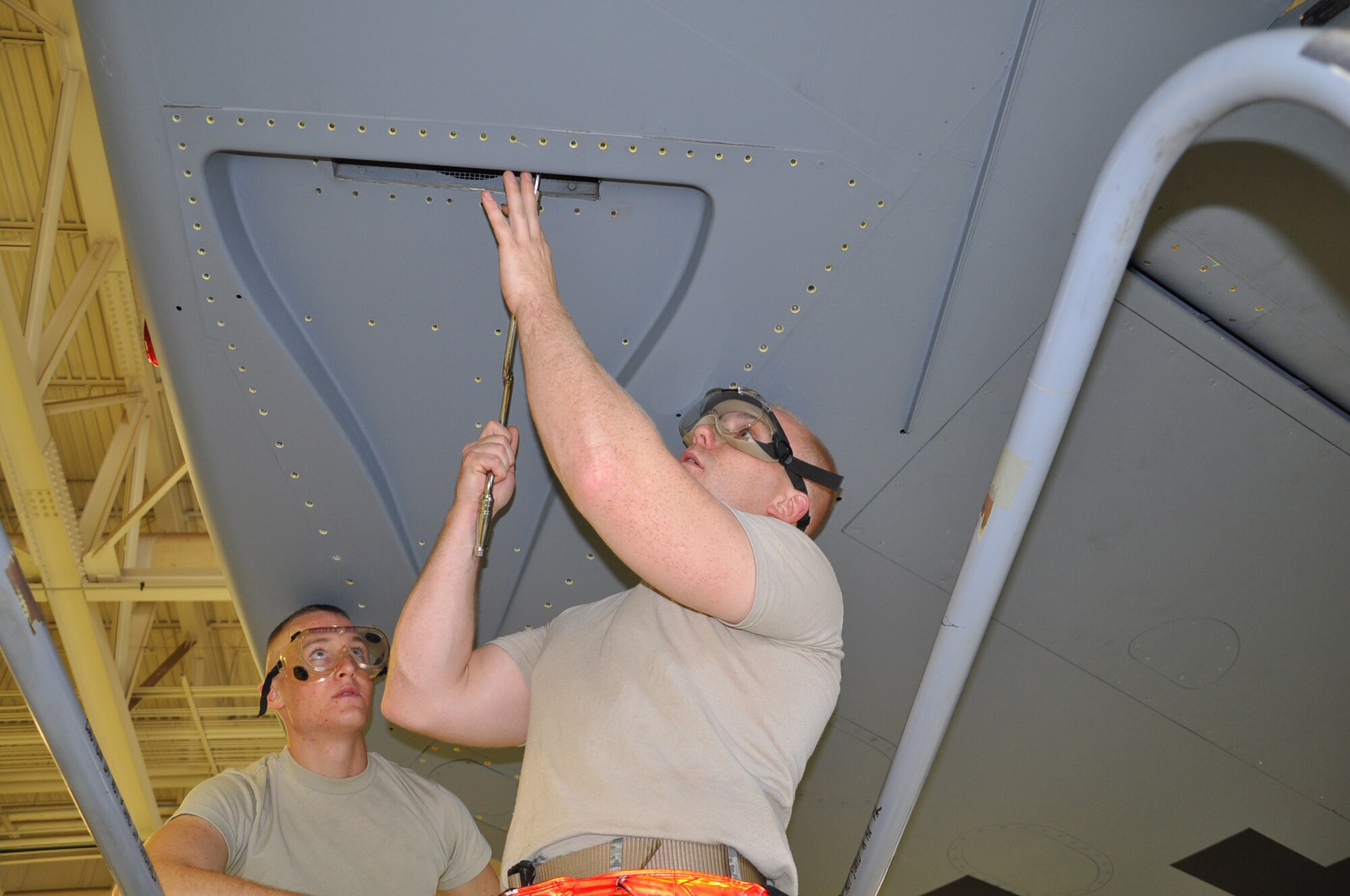 Senior Airman Adam Michel and Airman 1st Class Roland Cox, fuel system repair specialists from the 22nd Maintenance Squadron, remove a ram air scoop from a KC-135 Stratotanker wing in preparation for a wing tip-to-wing tip fuel leak inspection and repair. (Air Force photo by Brannen Parrish)
