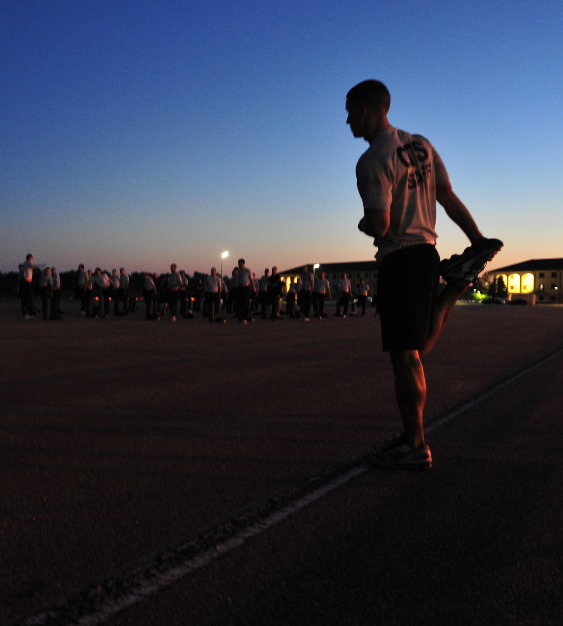 Capt. Ryan M. Thompson, 24th Training Squadron flight commander, Officer Training School, Maxwell Air Force Base, Ala. stretches during morning PT with officer trainees. (U.S. Air Force photo by Senior Airman Christopher Stoltz)