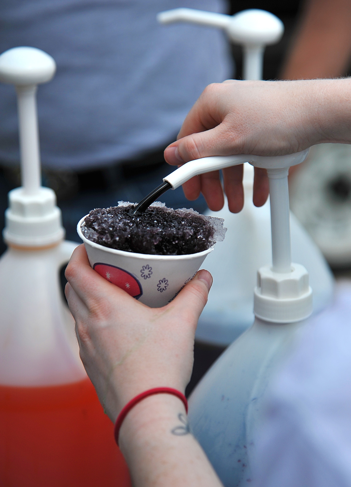 GOODFELLOW AIR FORCE BASE, Texas-- A volunteer flavors a snow cone at the 2012 Children’s Festival April 7. With the temperature beginning to heat up, the snow cones were very popular with the families. (U.S. Air Force photo/Airman 1st Class Michael Smith)