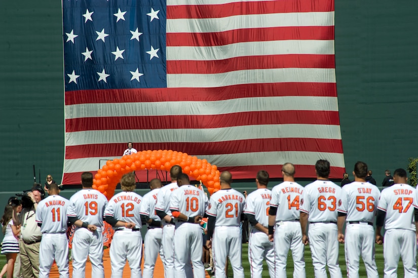 BALTIMORE, Md. -- Members of the Baltimore Orioles observe the singing of The National Anthem before their season opener April 4.  The 1st Helicopter Squadron from Joint Base Andrews, Md., contributed to the ceremonies with a flyover display during closing notes of The National Anthem.    (Photo/Bobby Jones)