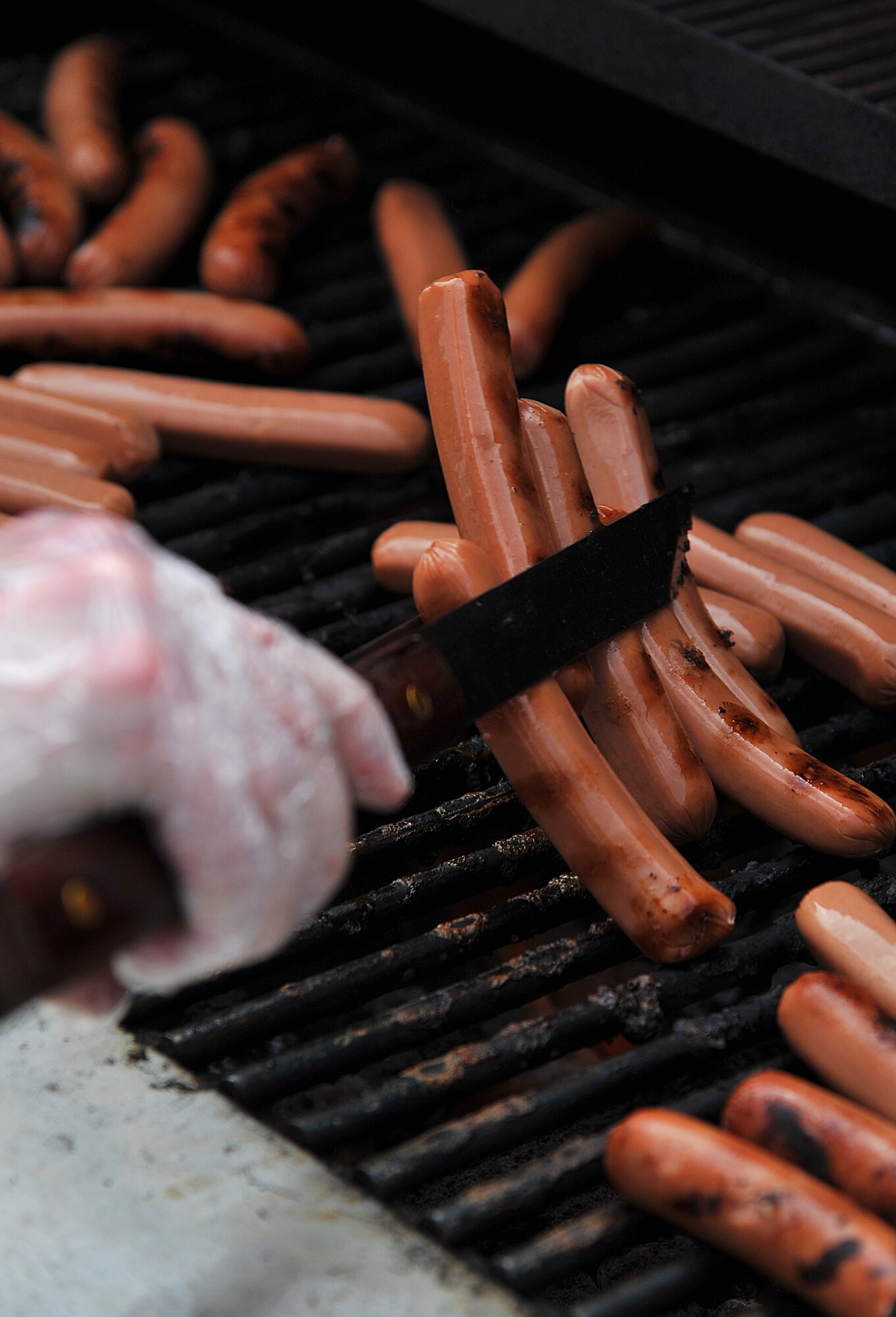 GOODFELLOW AIR FORCE BASE, Texas-- A volunteer flips hotdogs on the grill during the 2012 Children’s Festival April 7. With the large group of families attending the festival the food quickly left the grill. (U.S. Air Force photo/Airman 1st Class Michael Smith)