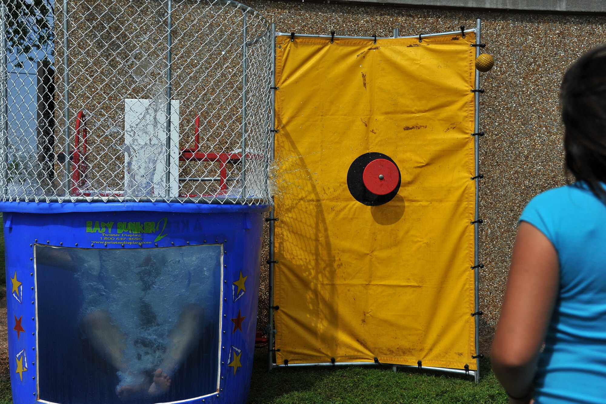 GOODFELLOW AIR FORCE BASE, Texas-- Airman 1st Class John Cummins, 312th Training Squadron student, falls into the water of the dunking booth during the 2012 Children’s Festival April 7. The event had activities for kids of all ages to enjoy with their families. (U.S. Air Force photo/Airman 1st Class Michael Smith)