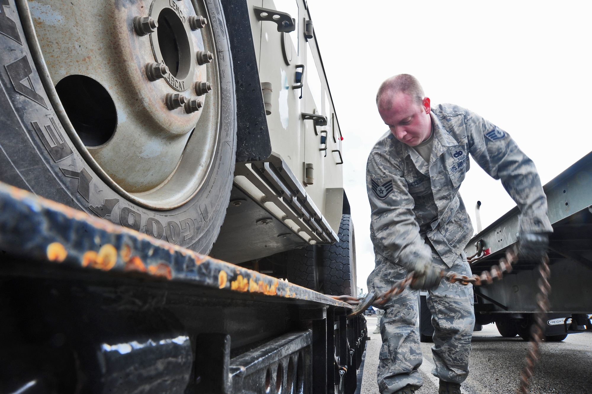 WHITEMAN AIR FORCE BASE, Mo. -- Staff Sgt. Christopher Waters, 509th Logistics Readiness Squadron vehicle trainer, chains down a government vehicle on a trailer March 23. Vehicles are chained down on trailers so they don’t roll off during travel. (U.S. Air Force photo/Senior Airman Nick Wilson)