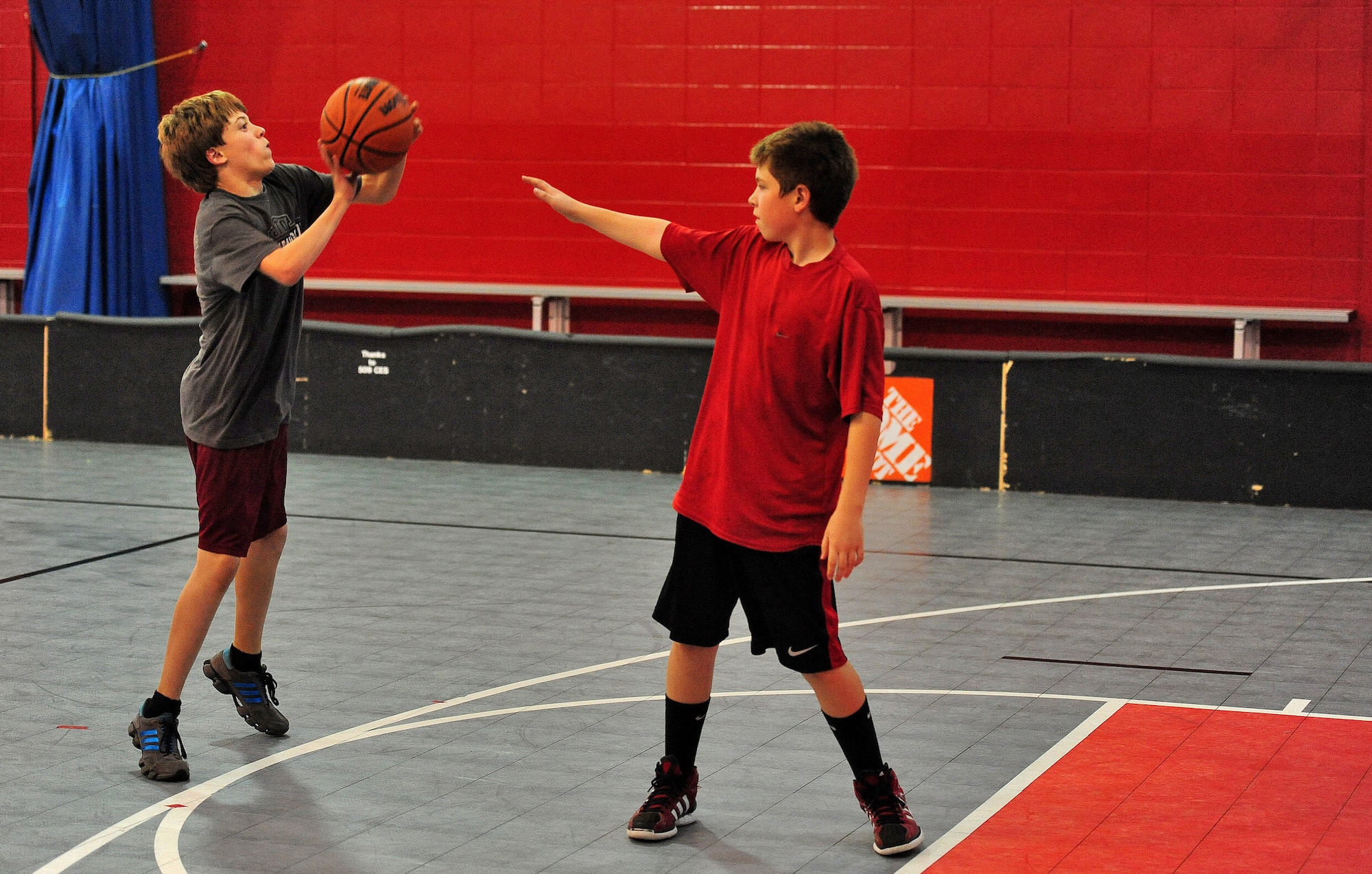 WHITEMAN AIR FORCE BASE, Mo. -- James Bodine, son of Lt. Col Ron Bodine, 394th Combat Training Squadron commander, shoots the basketball as Jacob Rice, eighth grade student at Warrensburg Middle School, tries to block him in the Youth Center Gymnasium during Operation Night Hoops March 30. Operation Night Hoops is a monthly event open to all teenagers from the ages of 13 to 18. Adults older than 18 are encouraged to volunteer as chaperones and be role models. (U.S. Air Force photo/Senior Airman Nick Wilson)