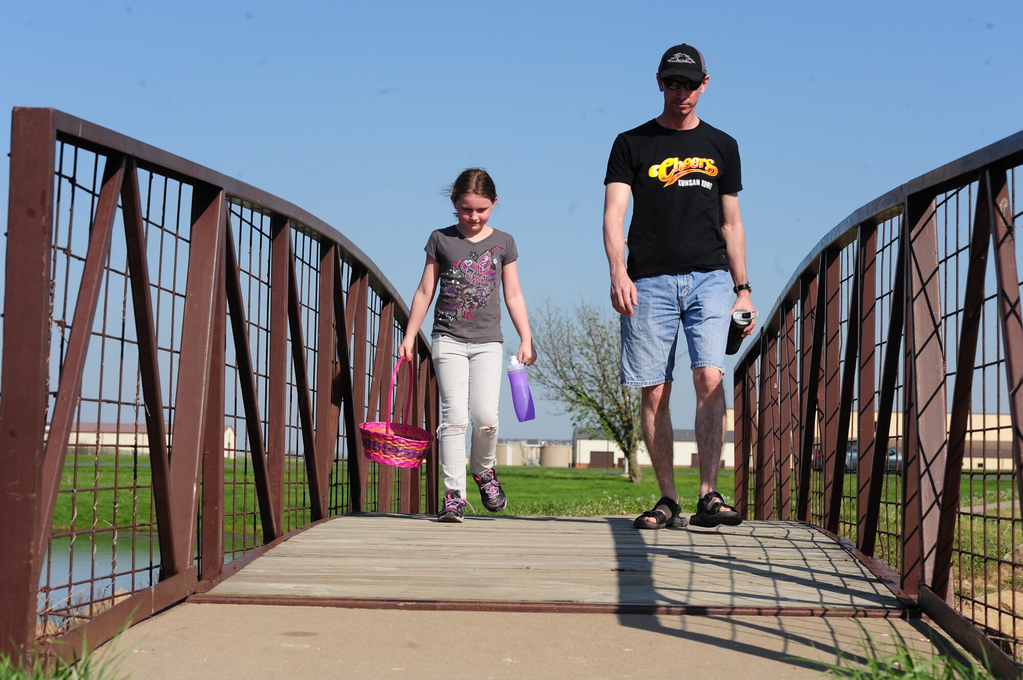 WHITEMAN AIR FORCE BASE, Mo. -- Master Sgt. Paul Morse, 509th Aircraft Maintenance Squadron unit security manager, walks across a bridge with his daughter, Kali, during a 509th AMXS Easter Egg Hunt at Ike Skelton Park March 31. Not only was the event held to increase morale, but it helped create a bond among Airmen in the squadron, their families and coworkers. (U.S. Air Force photo/Senior Airman Nick Wilson)