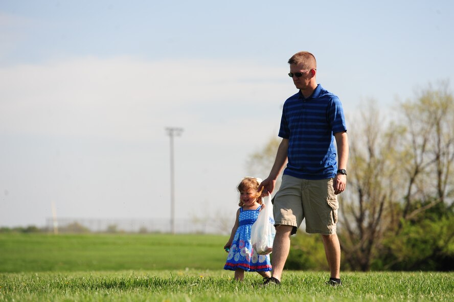 WHITEMAN AIR FORCE BASE, Mo. -- Tech. Sgt. Casey Hust, 393rd Aircraft Maintenance Unit  instruments and flight controls element, searches for Easter eggs with his daughter Ryleigh, during a 509th AMXS Easter Egg Hunt Ike Skelton Park March 31. The event was organized to bring Airmen and their families together and increase morale. (U.S. photo/Senior Airman Nick Wilson)