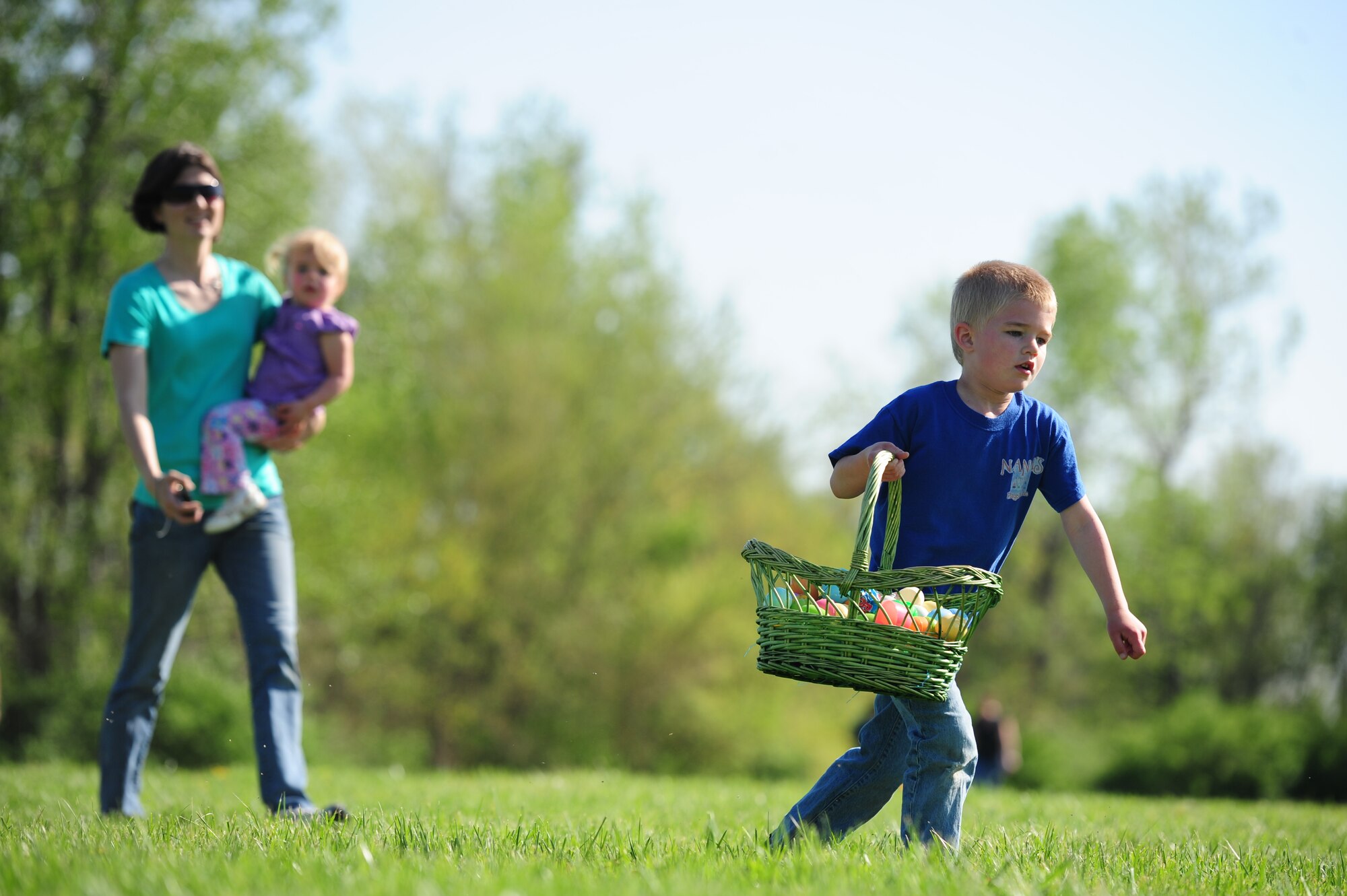 WHITEMAN AIR FORCE BASE, Mo. – Luke Shadden, five-year-old, runs with a basket full of Easter eggs as his mother, Capt. Kristen Shadden, 509th Aircraft Maintenance Squadron aircraft maintenance unit officer in charge, and sister Leah, follow during a 509th AMXS Easter Egg Hunt Ike Skelton Park March 31. The event was organized and sponsored by the 509th AMXS Key Spouse Group. (U.S. Air Force photo/Senior Airman Nick Wilson)