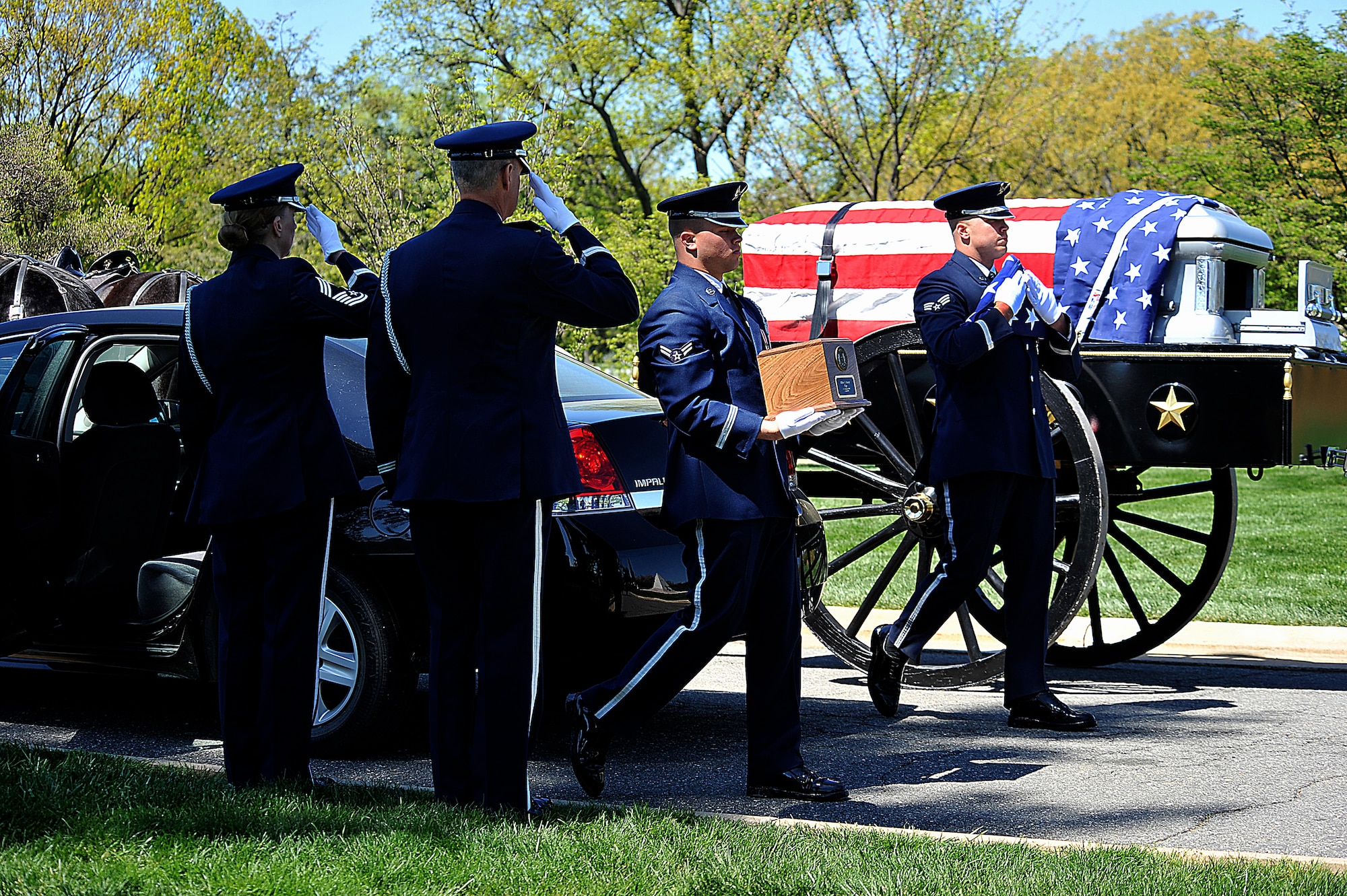 Airman 1st Class Josh Busch, center, carries an urn containing the remains Tech. Sgt. Allen J. Avery while Senior Airman Jeremy Dotson, background, carries a folded American flag during Avery's burial ceremony at Arlington National Cemetery, Va., April 6, 2012. Avery was part of a combat search and rescue mission aboard an HH-53C Super Jolly Green Giant helicopter when they were shot down over Quang Tri province, South Vietnam, April 6, 1972. Saluting in the foreground are Chief Master Sgt. Diane Munson, left, and Col. Charles Cornelisse, a chaplain. The Airmen are with the U.S. Air Force Honor Guard. (U.S. Air Force photo by Val Gempis)