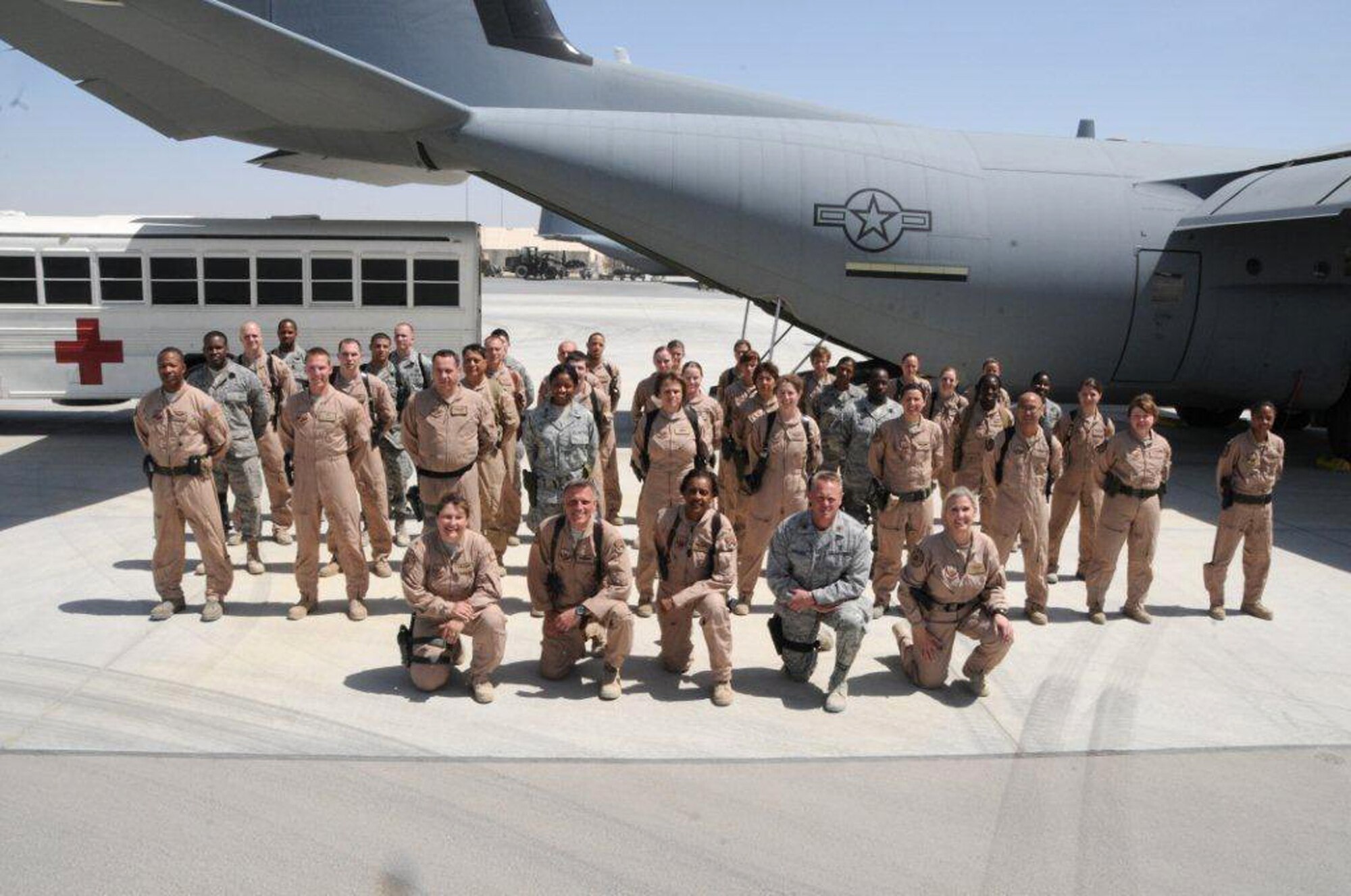 Memebers of the 651st Expeditionary Aeromedical Evacuation Squadron, Kandahar Airfield, Afghanistan, in front of their medical bus and C-130 Hercules aircraft, April 6, 2012. Maj. Peter Jorgensen, out of the 446th Aeromedical Evacuation Squadron, McChord Field, Wash., is deployed as the 651st EAES director of operations and is responsible for overseeing the daily duties of more than 100 people, who support around-the-clock aeromedical evacuations for more than 100,000 NATO troops. (U.S. Air Force photo/Staff Sgt. Heather Skinkle)