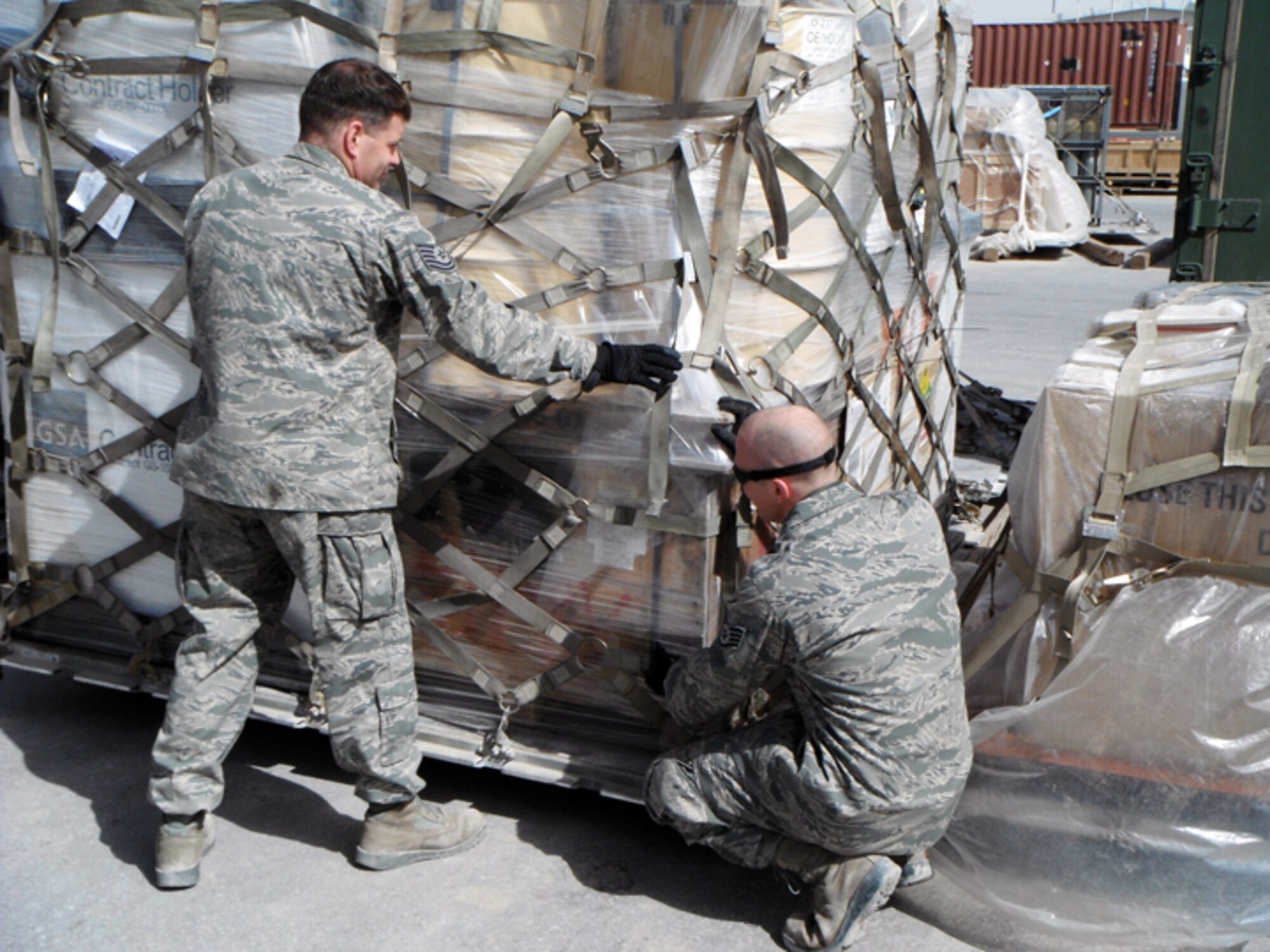 Deployed members of the 25th Aerial Port Squadron are proving the truth of the unit motto, "Anytime ... Anywhere." Tech. Sgts. Ian Murphy and Armen Weinrick prepare a pallet.