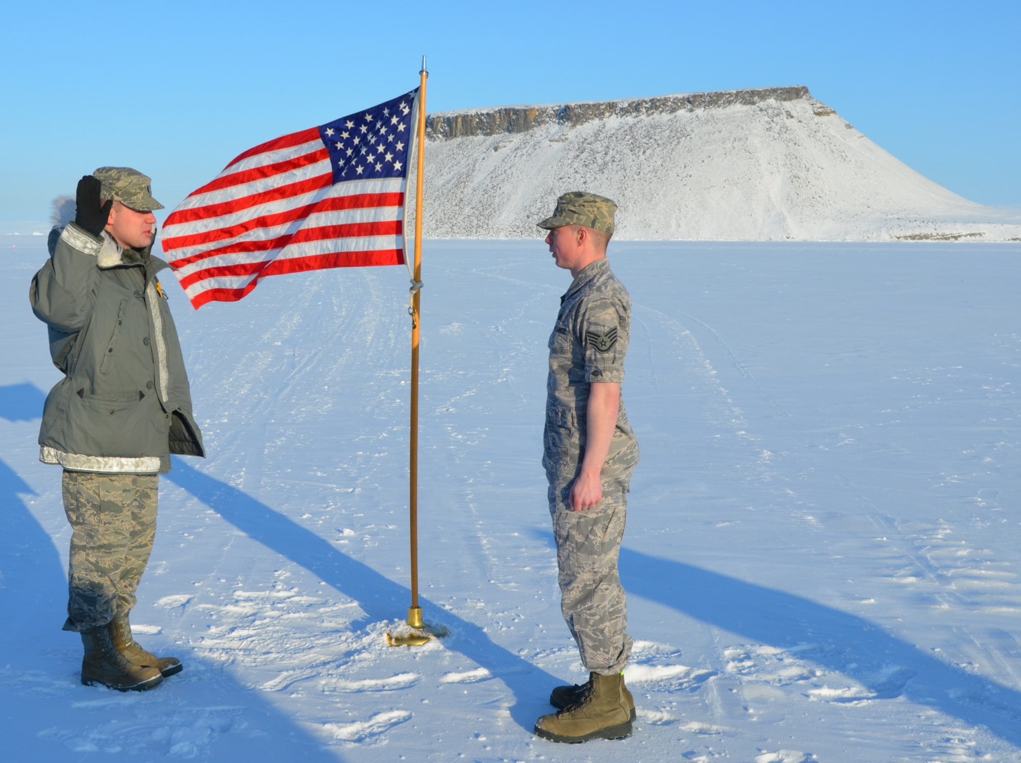 THULE AIR BASE, Greenland – 1st Lt. Ariel Torgerson (left), 821st Support Squadron Communications Flight commander, issues the oath of enlistment to Staff Sgt. Eric Jennings, 821st SPTS, March 30 in view of Mount Dundas, Greenland. The 821st Air Base Group, which operates the base, is one of the 21st Space Wing’s groups and is home to the northernmost deep water port in the world. Jennings took advantage of the unique opportunity to have his re-enlistment take place on the ice of the North Bay. He is a client systems technician and re-enlisted for five more years of service. (U.S. Air Force photo/Tech. Sgt. Darrell Kinsey)