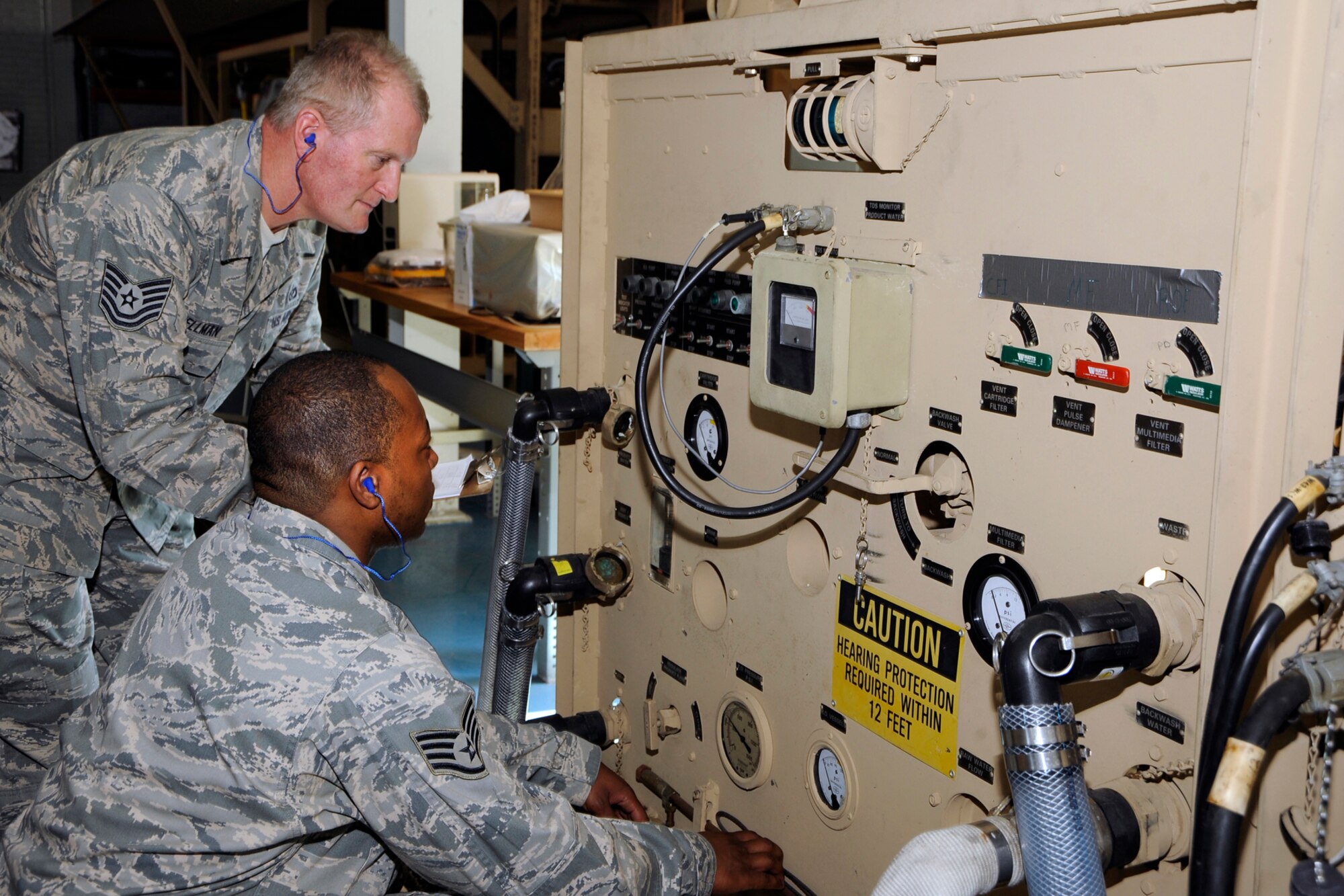 TSgt. Chris Wellman and SSgt. Henry McCall perform a maintenance check on a mobile water purification system at Selfridge Air National Guard Base, Mich., as part of their duties as Water & Fuels System Maintenance specialists with the 127th Civil Engineer Squadron at Selfridge Air National Guard Base. In his civilian job, Wellman is a licensed master plumber. McCall is a full-time student in a construction management program. Both are members of the Michigan Air National Guard. (U.S. Air Force photo by John S. Swanson)