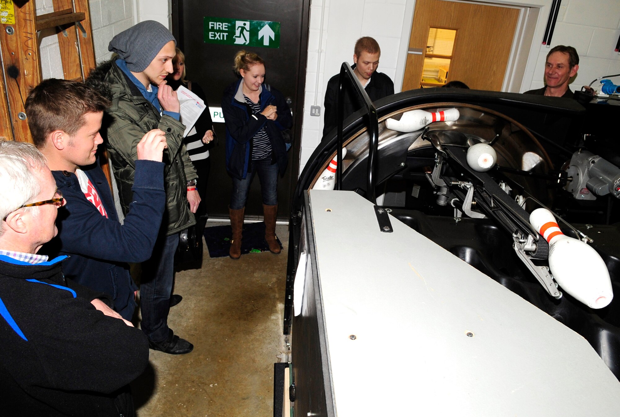 RAF MILDENHALL, England – Members of the Teenage Cancer Trust get a first-hand look at how the bowling pin dispenser works during a tour of the Bowling Center here April 4, 2012. The TCT is a charity that aims to provide teenagers and young adults who have cancer with the best possible care and professional support available. (U.S. Air Force photo/Senior Airman Ethan Morgan)