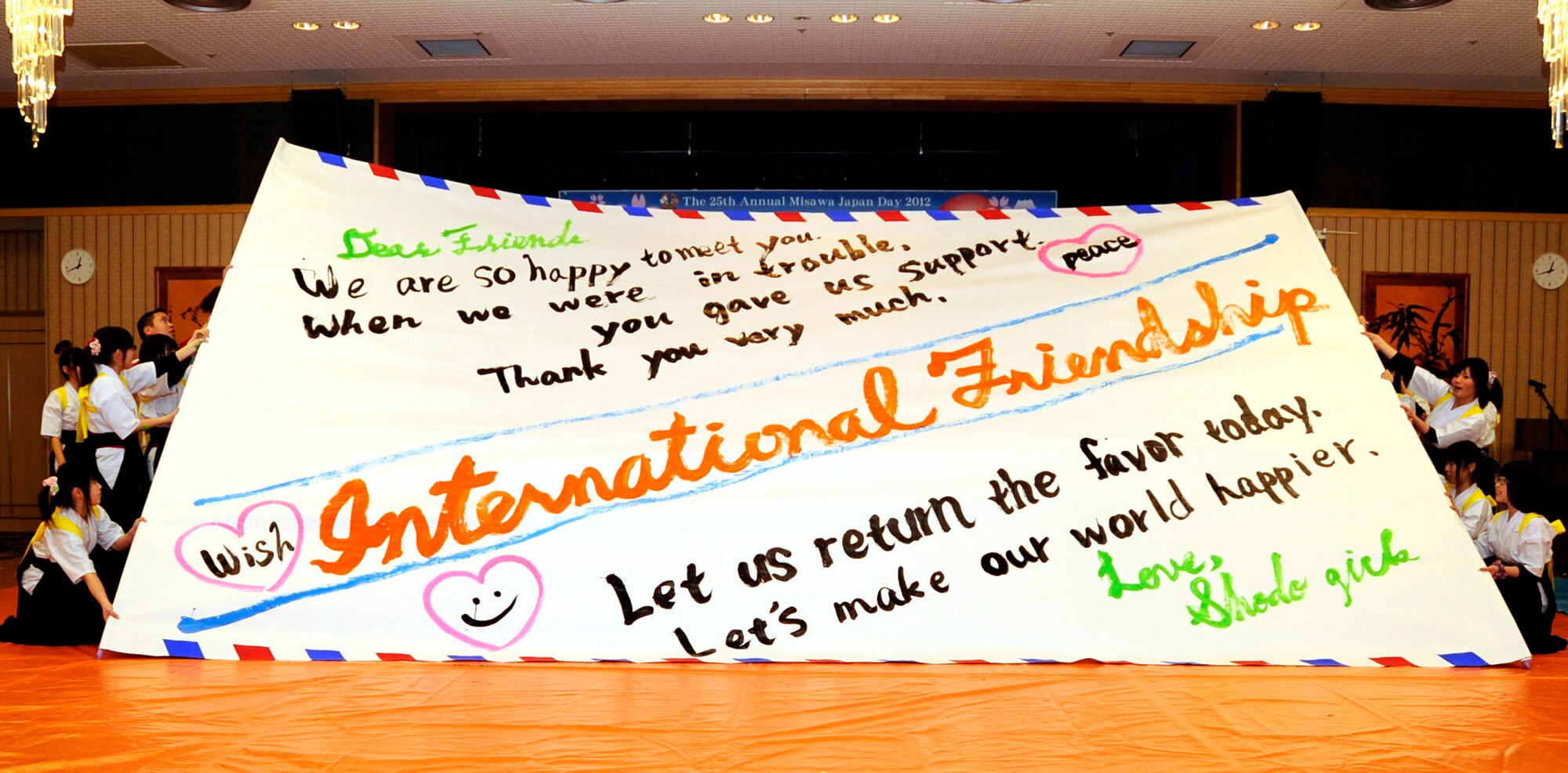 Students from Hachinohe Higashi High School hold up a finished product from their calligraphy dance during the 25th Annual Japan Day at Misawa Air Base, Japan, April 7, 2012. The students combined dance and calligraphy to make large messages. (U.S. Air Force photo by Airman 1st Class Kaleb Snay/Released)