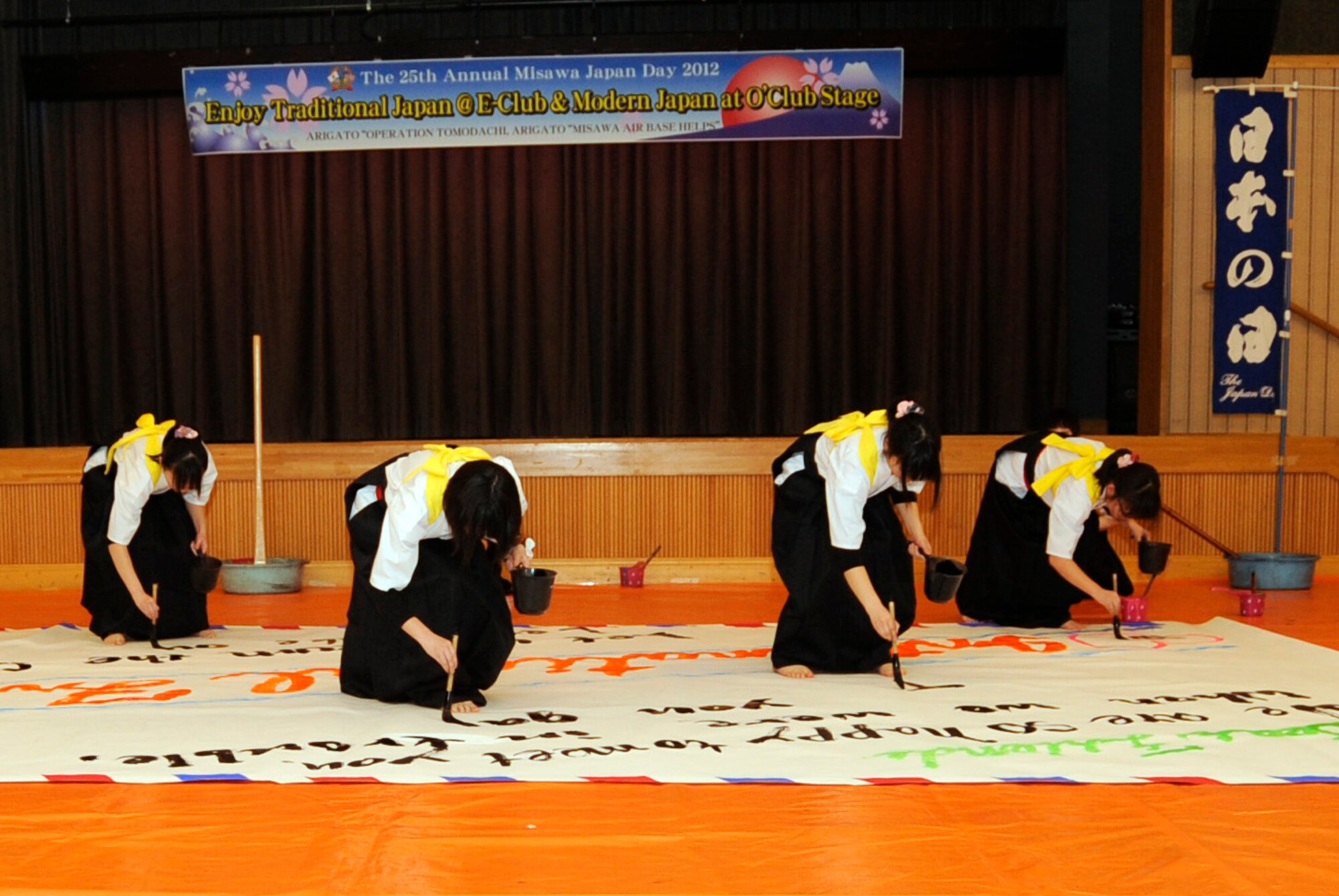 Students from Hachinohe Higashi High School perform a calligraphy dance during the 25th Annual Japan Day at Misawa Air Base, Japan, April 7, 2012. The students performed twice, making a large banner in Japanese and then one in English. (U.S. Air Force photo by Airman 1st Class Kaleb Snay/Released)