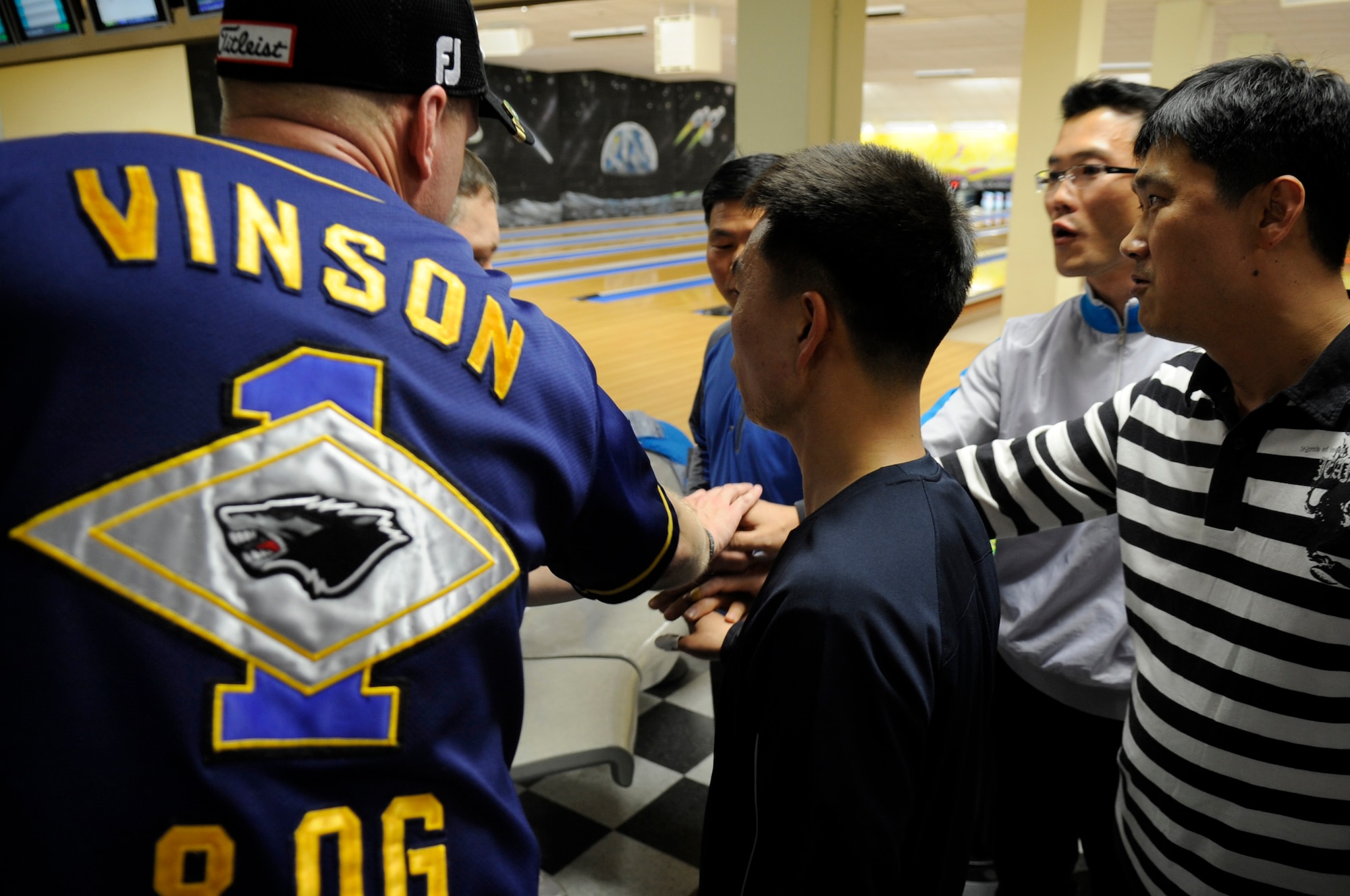 A bowling team of senior enlisted members from both the 8th Fighter Wing and 38th Fighter Group huddle together before a game at the Take it North Bowling Center on Kunsan Air Base, ROK, April 2, 2012.  The event brought together Republic of Korea and U.S. Air Force Enlisted NCOs stationed on Kunsan Air Base to help foster open communication.  
