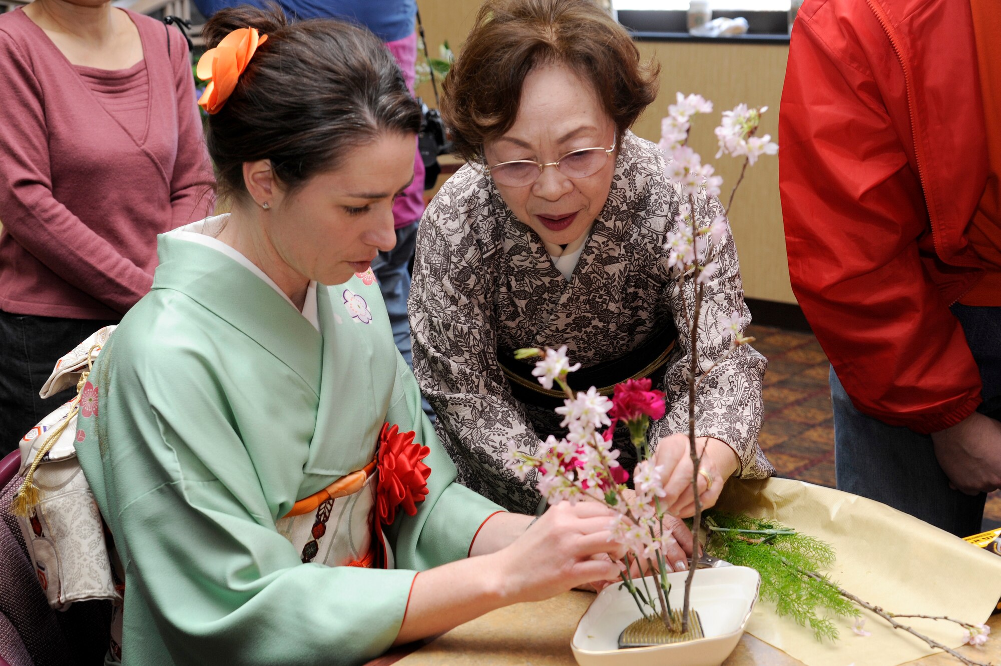 Jenn Rothstein, left, wife of U.S. Air Force Col. Michael D. Rothstein, 35th Fighter Wing commander, gets help from Kyoko Furuya as she properly arranges flowers during the 25th Annual Japan Day at Misawa Air Base, Japan, April 7, 2012. More than 50 cultural displays, hands-on demonstrations, live music, and theatrical demonstrations were available for Misawa residents to enjoy. (U.S. Air Force photo by Tech. Sgt. Marie Brown/Released)
