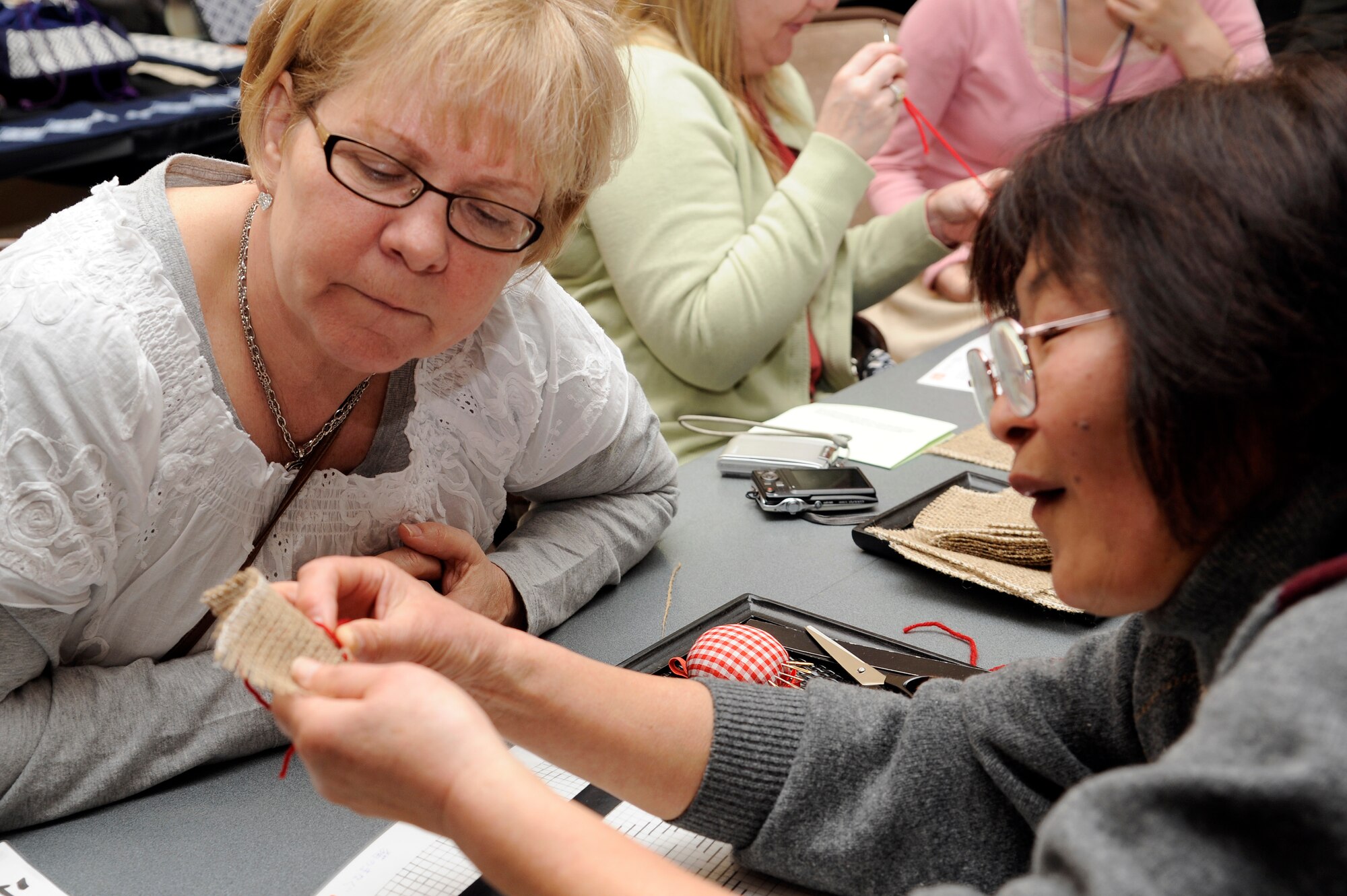 Linda Casale, left, mother of Jodi Hooks, Cummings Elementary School librarian, watches as Setsuko Abo shows her how to embroider during the 25th Annual Japan Day at Misawa Air Base, Japan, April 7, 2012. Japan Day was an opportunity for Misawa residents and their families to immerse themselves in various aspects of the Japanese culture. (U.S. Air Force photo by Tech. Sgt. Marie Brown/Released)
